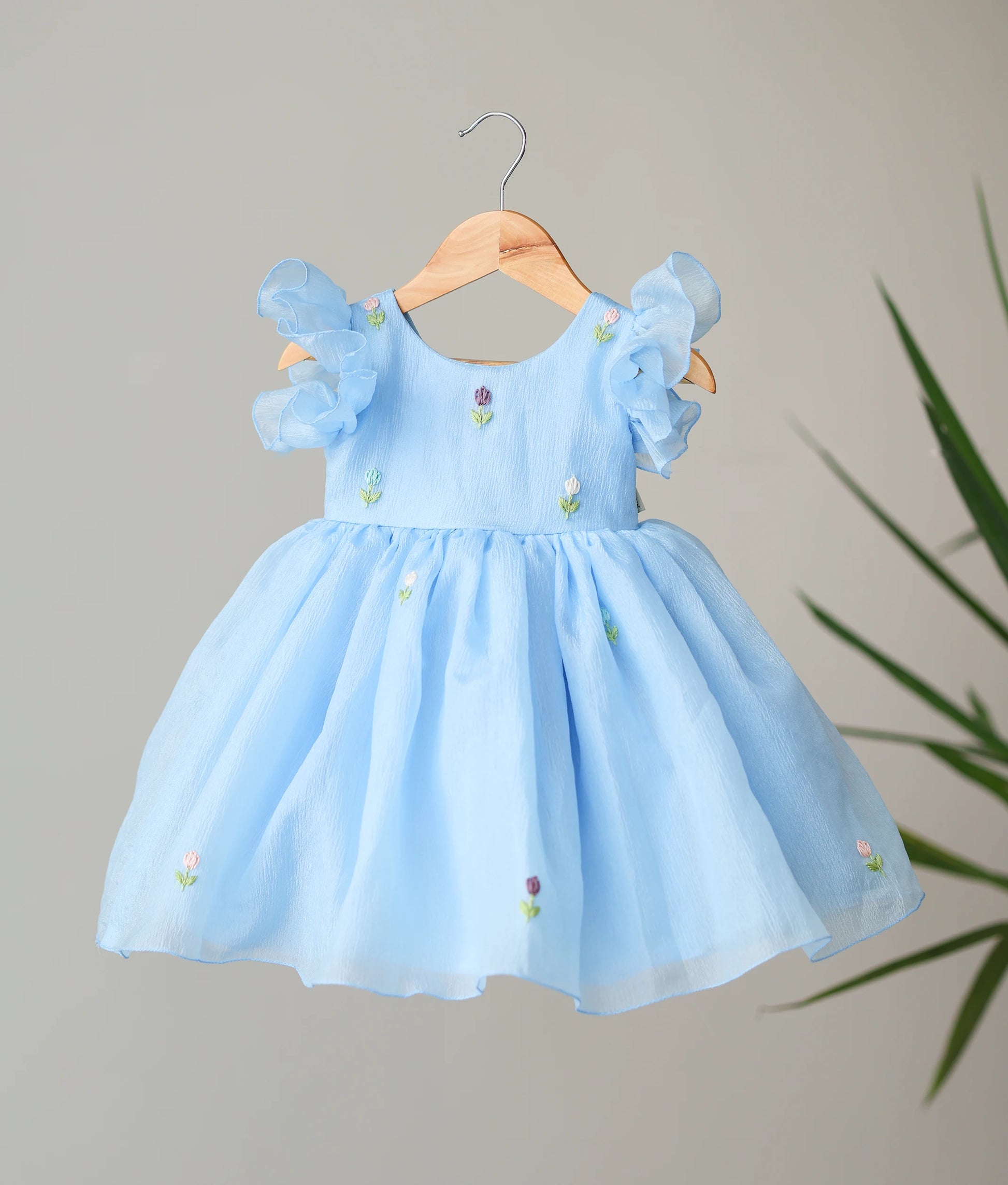 Front view of a pastel blue floral handworked crush organza birthday dress for baby girls featuring layered butterfly sleeves and a flared skirt