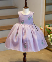 Front view of a pastel lavender crush organza birthday frock for baby girls featuring a floral handworked yoke and embroidered skirt