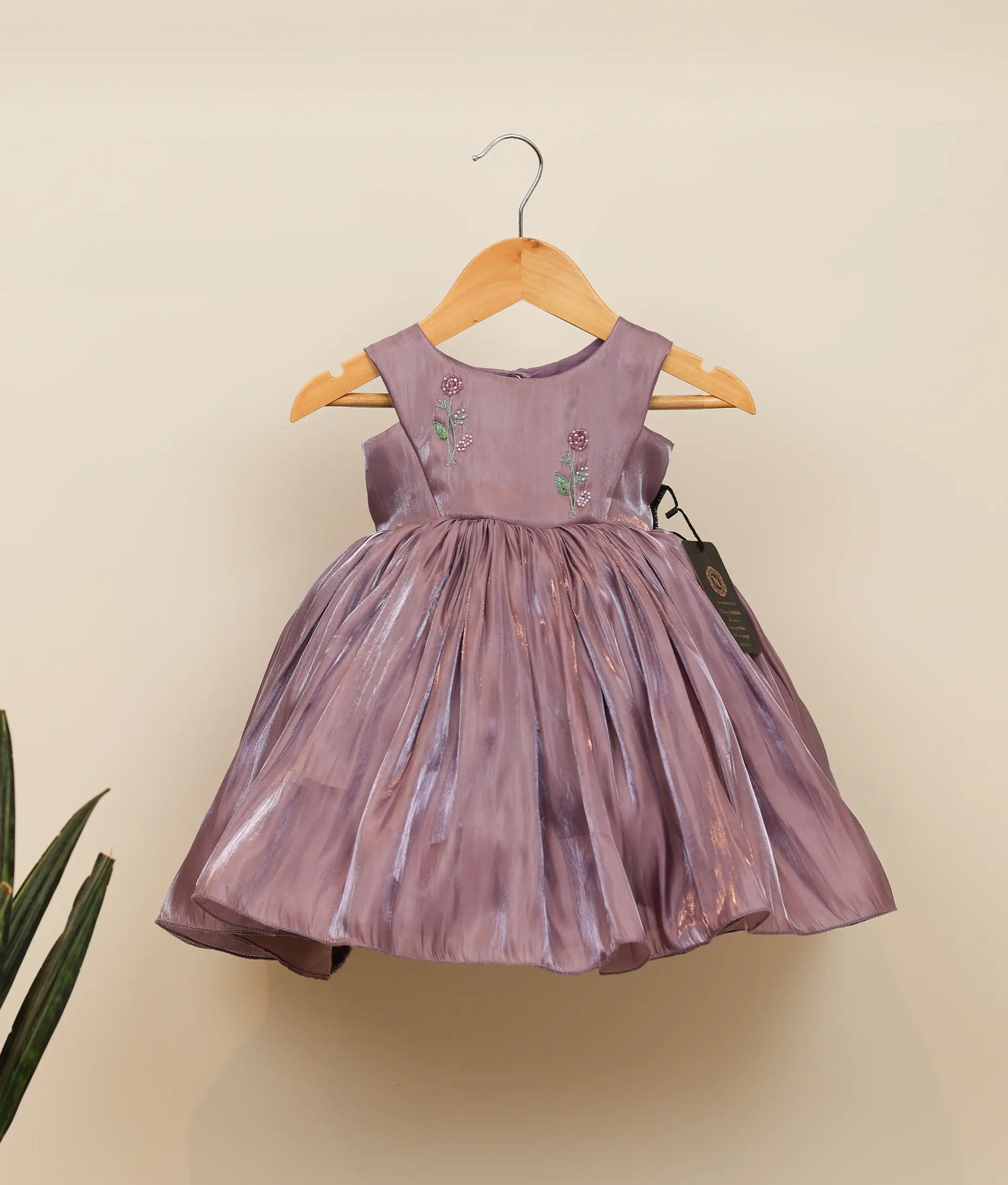 Front view of a pastel lavender laser organza birthday frock for baby girls featuring a floral handworked yoke and gathered flared skirt