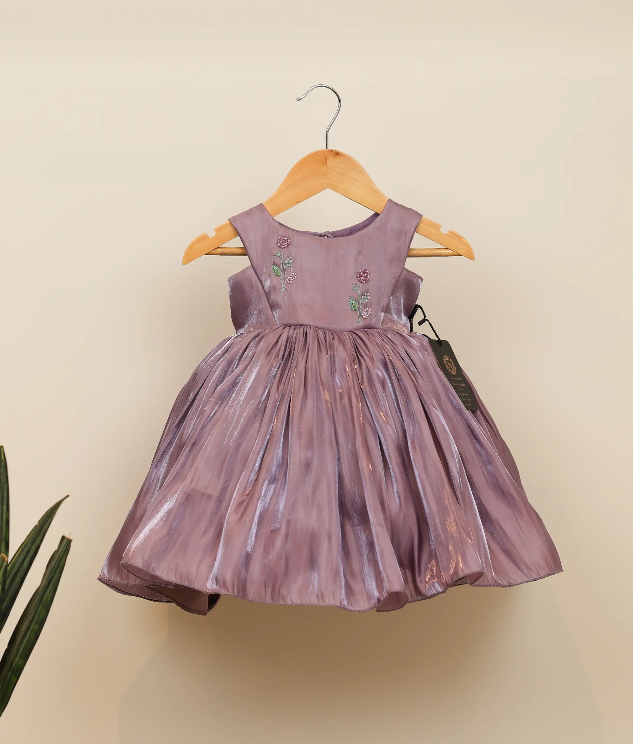 Front view of a pastel lavender laser organza birthday frock for baby girls featuring a floral handworked yoke and gathered flared skirt