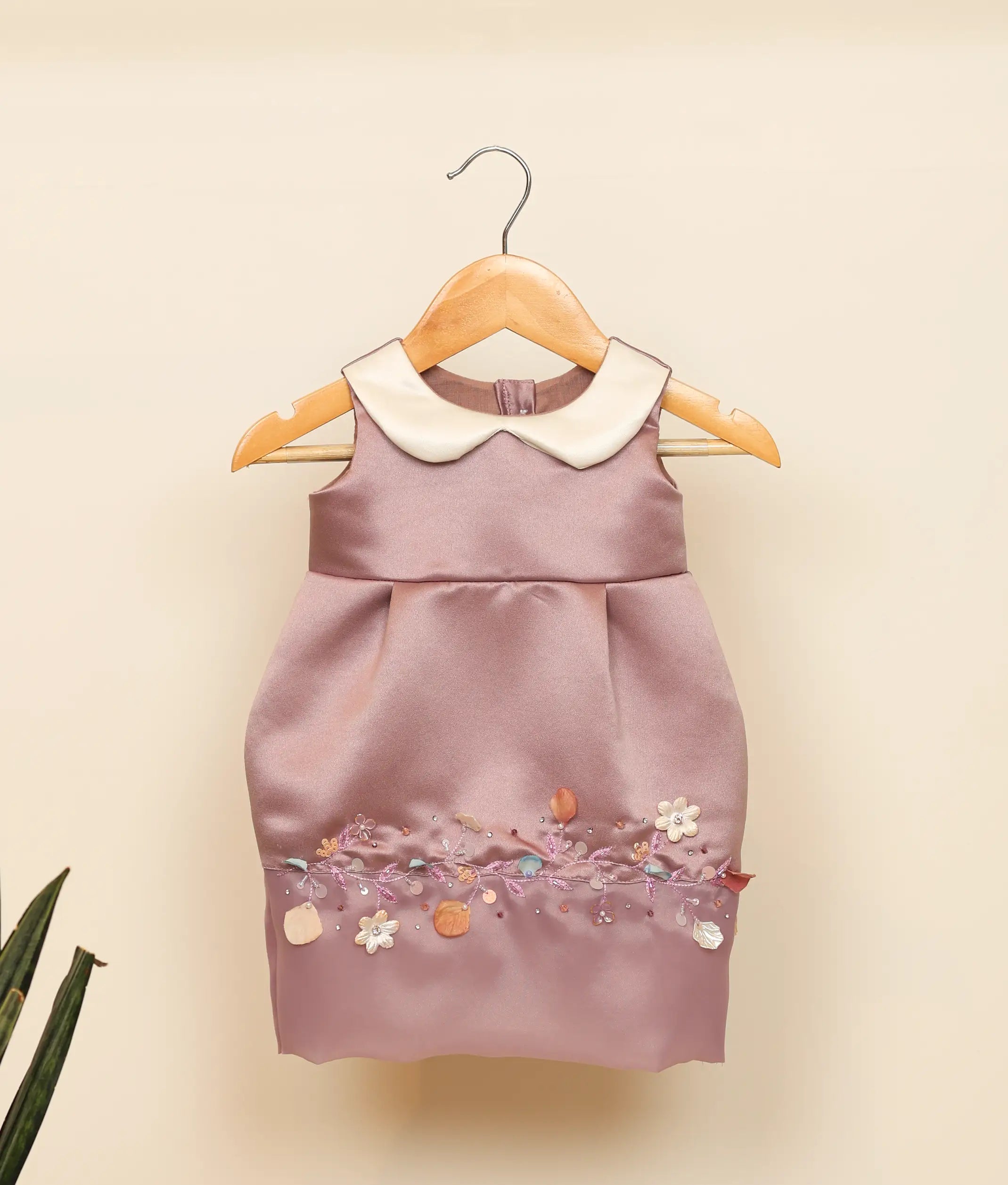 Front view of a pastel lavender satin fish-cut birthday frock for baby girls featuring a white Peter Pan collar and colorful floral hand-embellishment