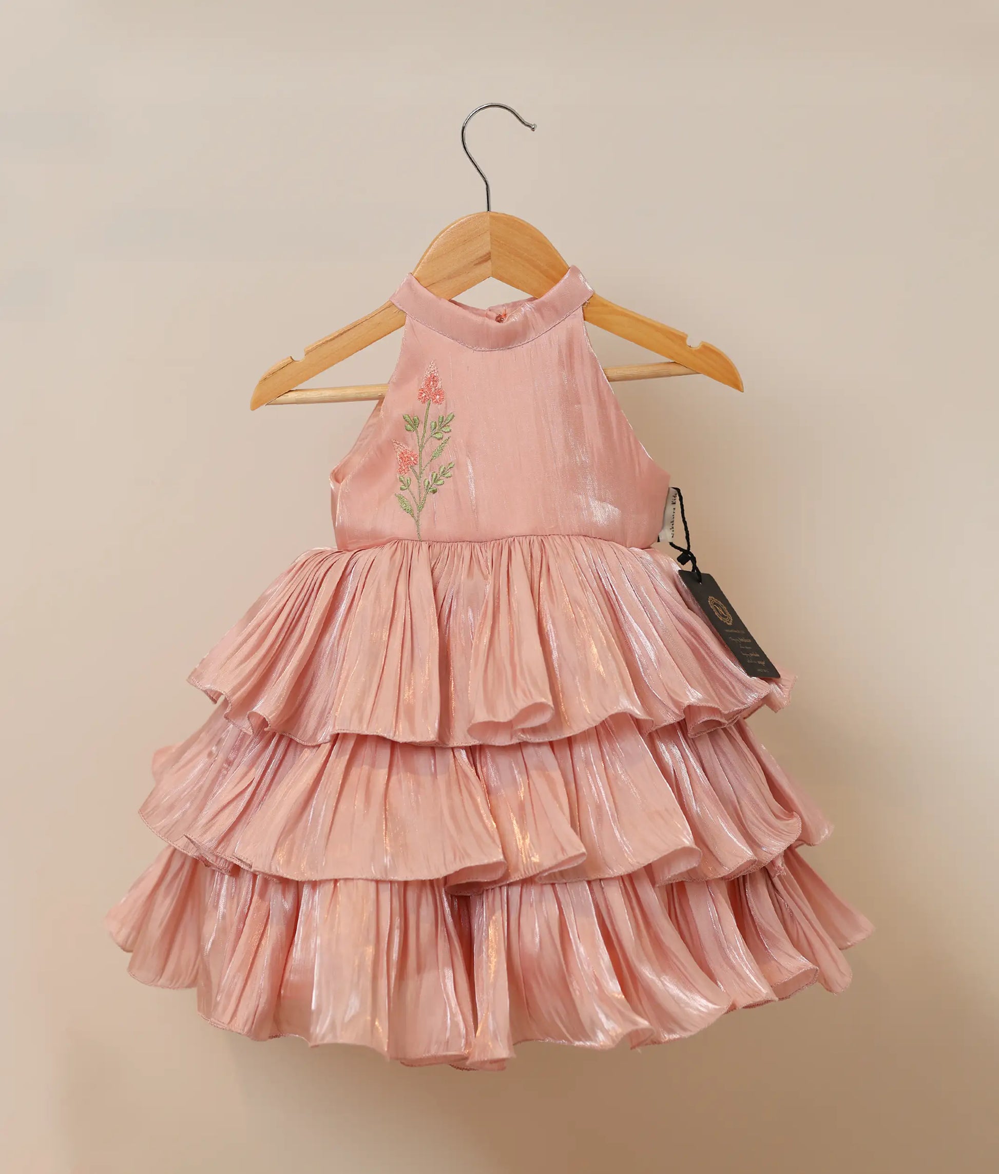 Front view of a pastel peach lacer organza birthday dress for baby girls featuring a halter-neck and multiple tiered ruffles