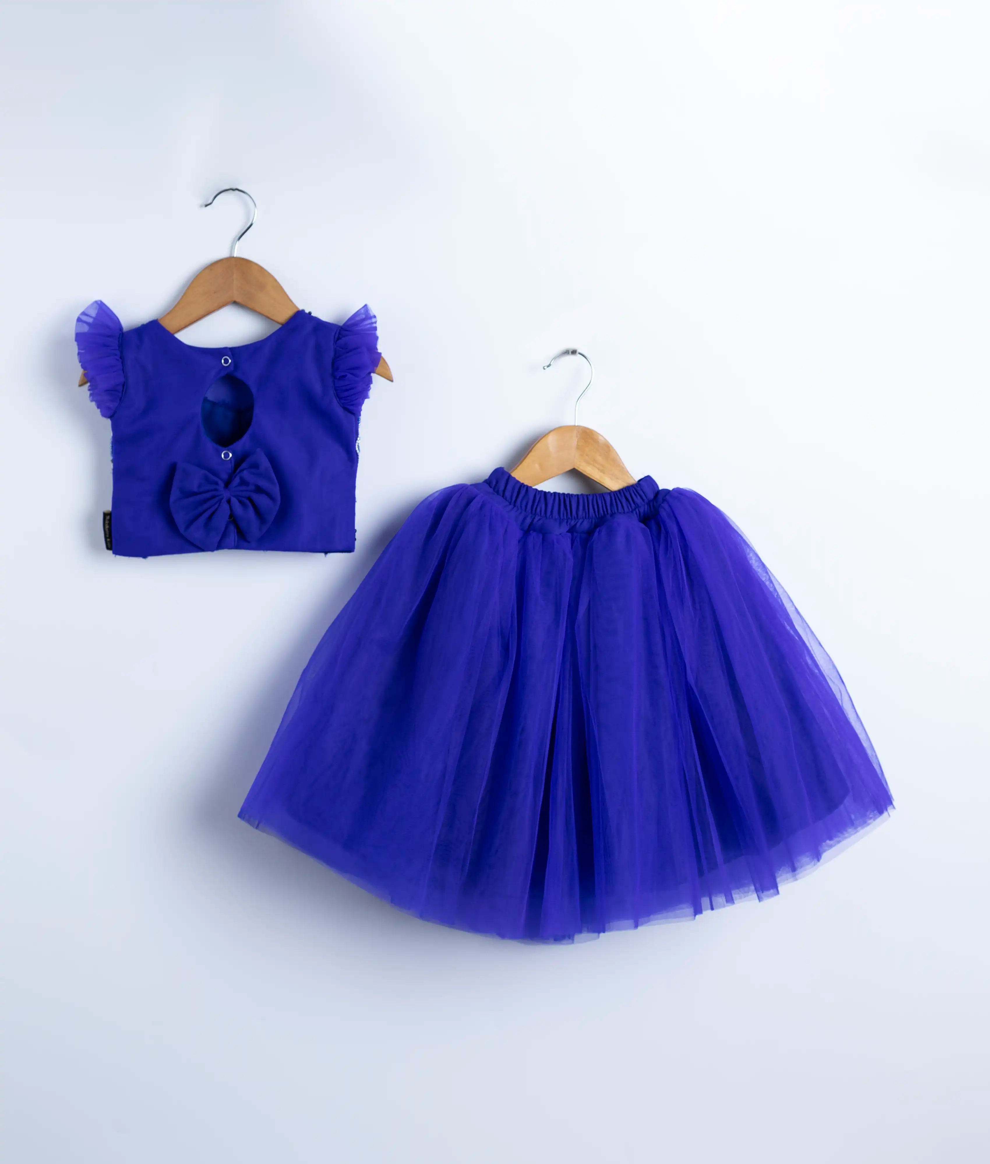 Flat lay of royal blue skirt and top set for baby girls with handmade embroidery and tulle