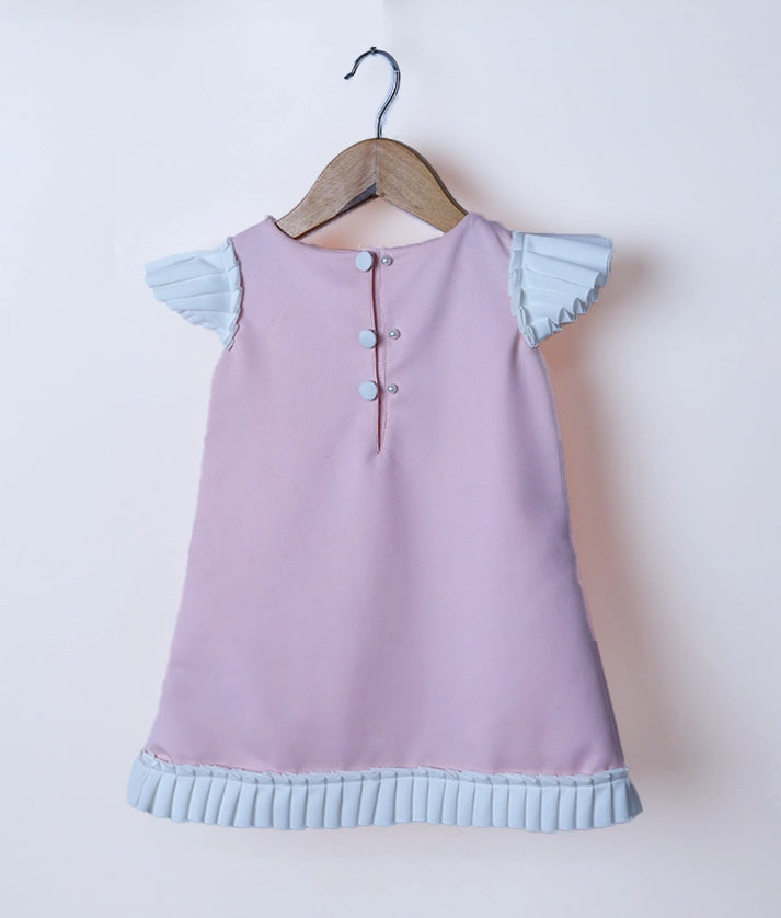 Back view of the baby pink candy frock highlighting the round neck and simple show button closure