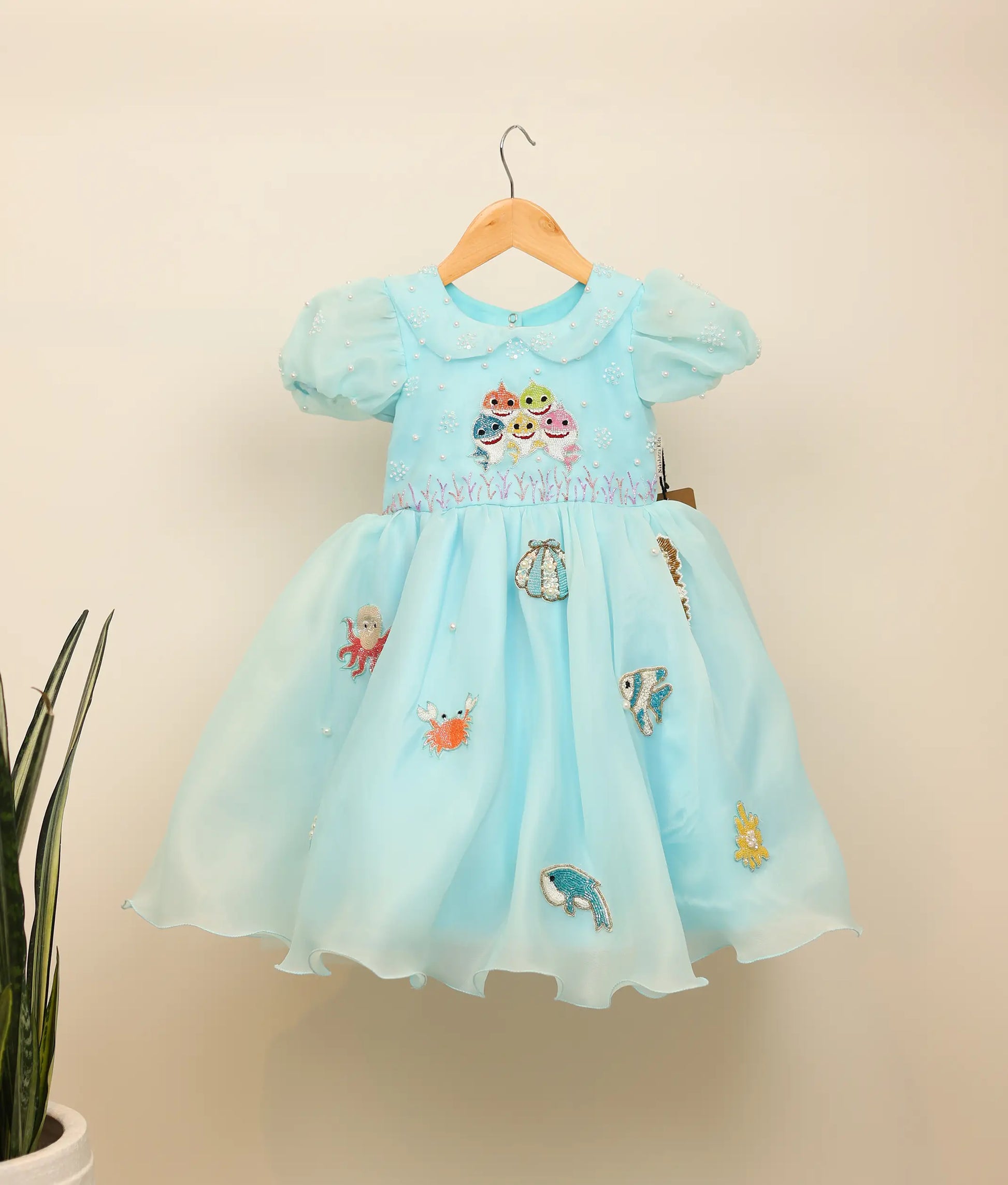 Front view of a sky blue Baby Shark theme birthday dress for girls with handworked characters and sea animals