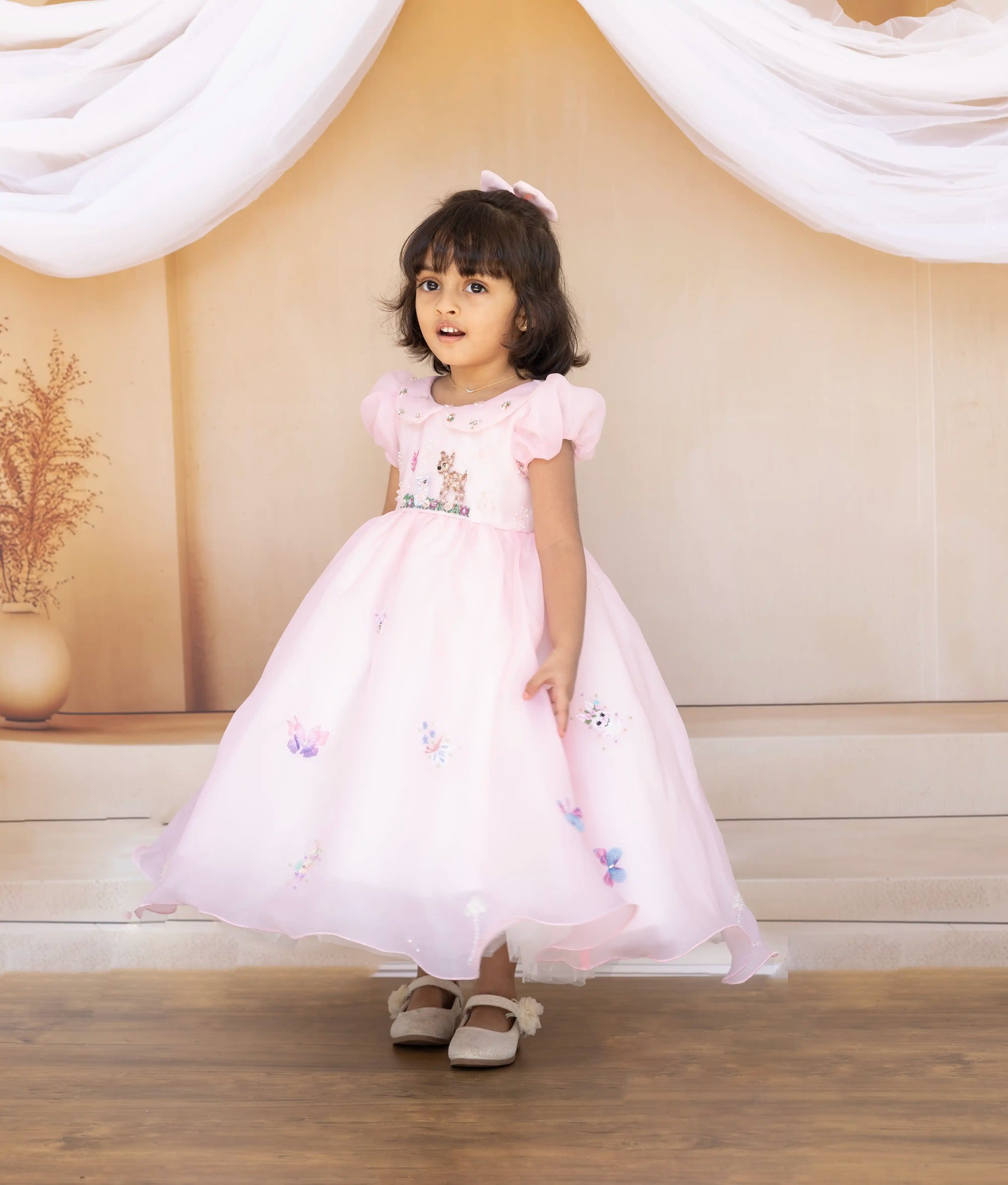 Back view of the pink organza birthday frock highlighting the round neck and button closure