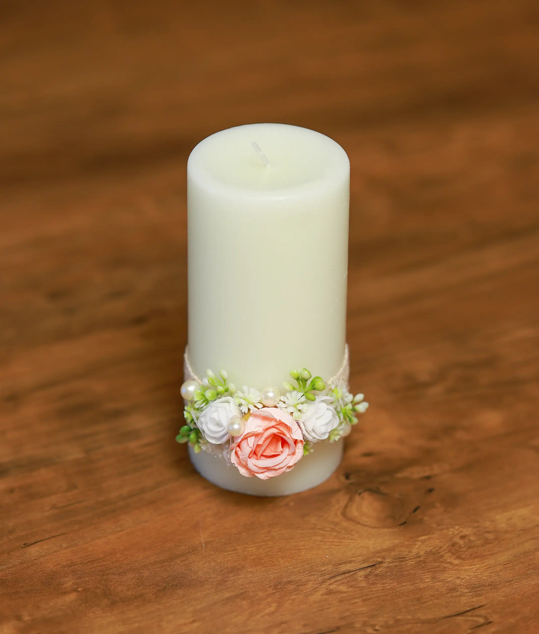 Close-up of the baptism candle showing the handmade peach rose, pearl accents, and white lace detailing