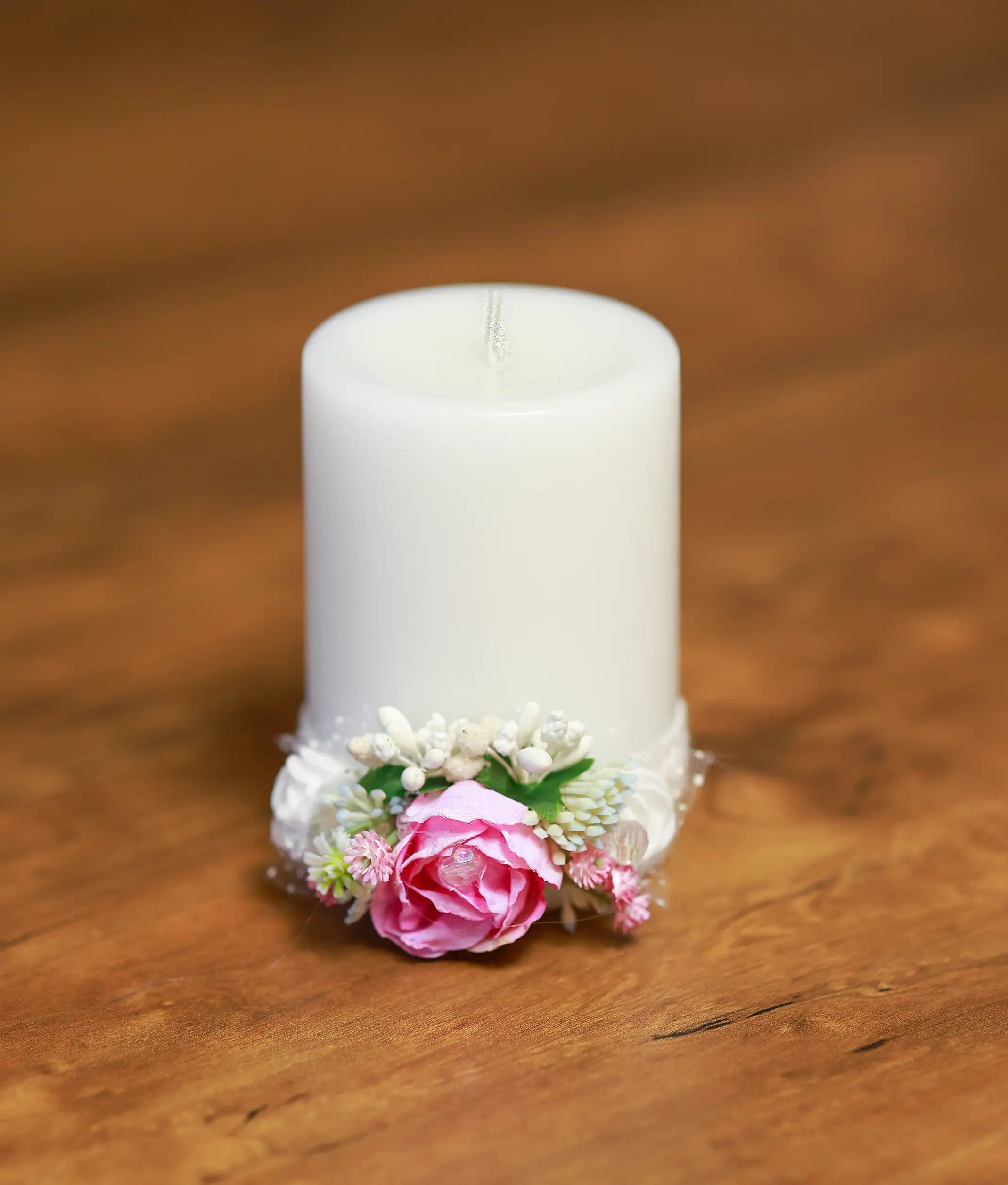 Close-up of the baptism candle showing the handmade pink rose, shimmering beads, and delicate white lace