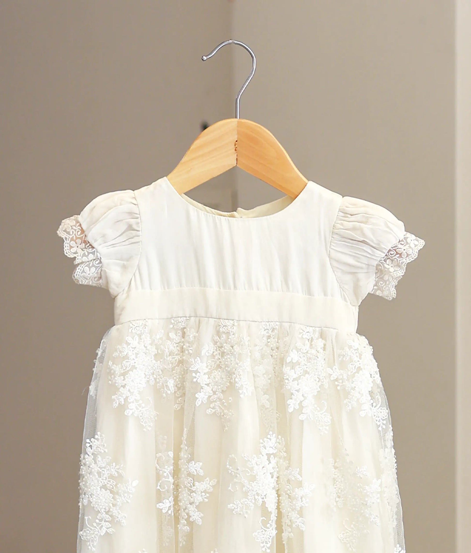 Close-up of the baptism gown showing the top and the beaded floral embroidery on the fabric.