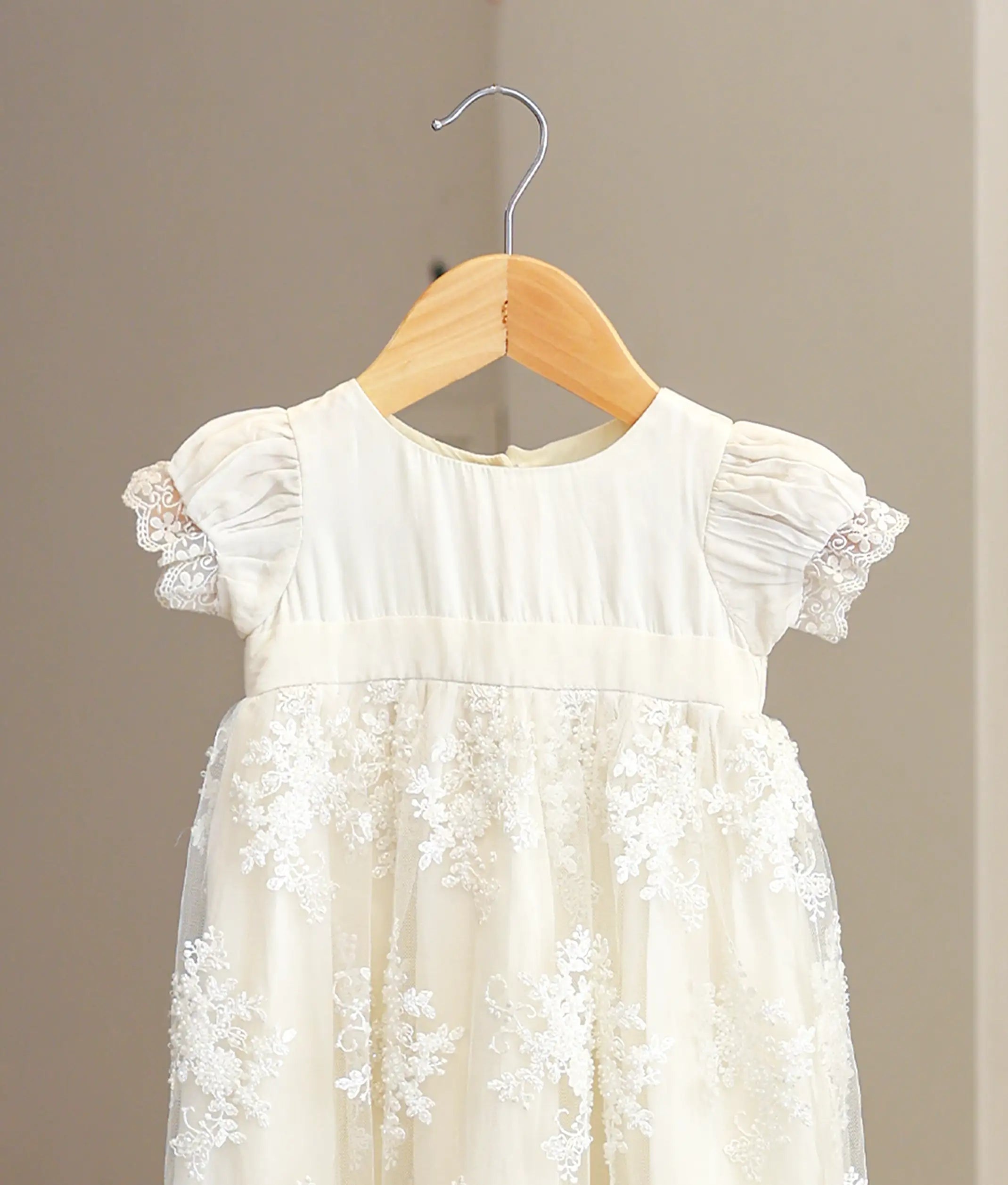Close-up of the baptism gown showing the top and the beaded floral embroidery on the fabric.