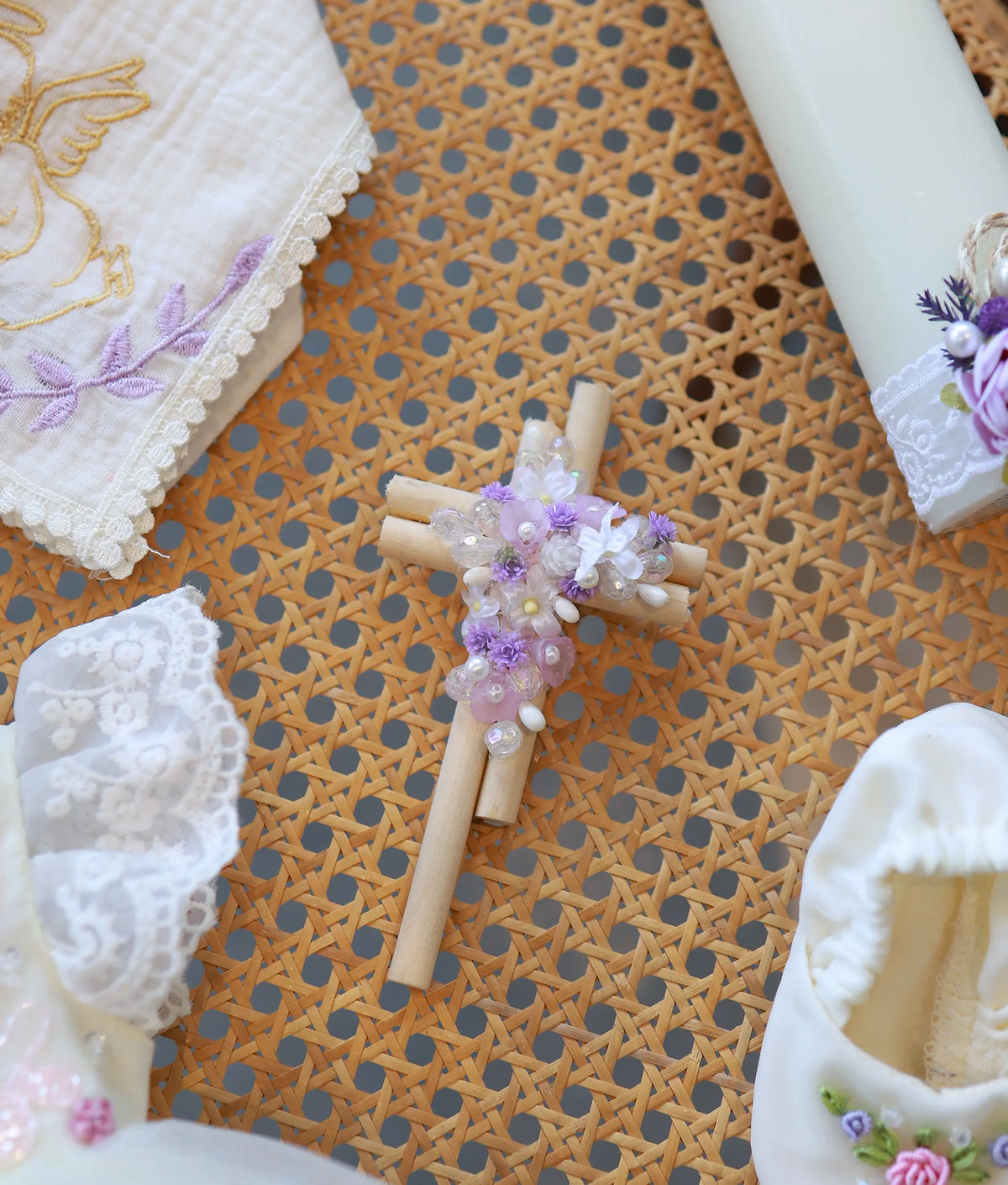 Detailed close-up of a decorative wooden cross embellished with purple and white floral beadwork.