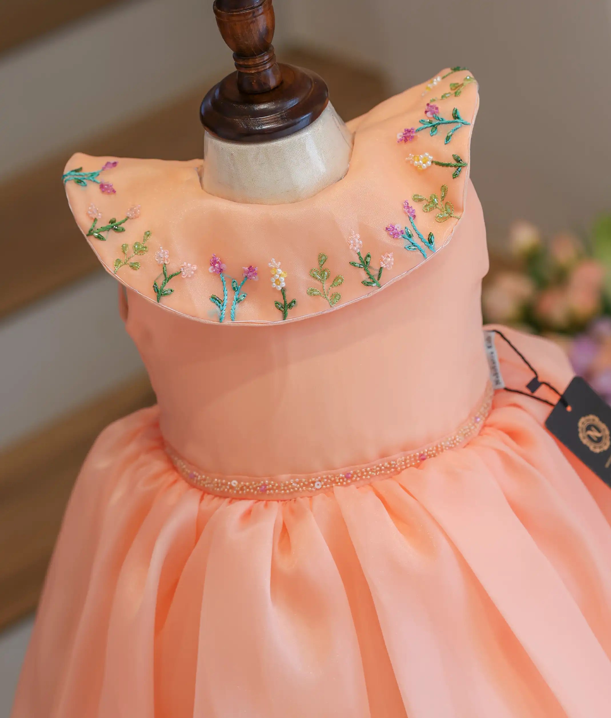 Close-up of the colorful flower embroidery on the Bertha collar and the beaded waist detailing.