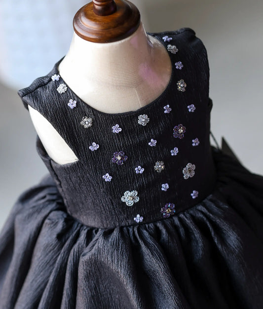 Close-up of the intricate white and silver floral handwork with beads and sequins on the yoke of the black birthday dress