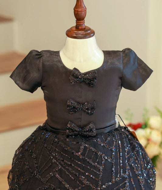 Close-up of the delicate hand embroidery and decorative small bow on the black bridal satin frock