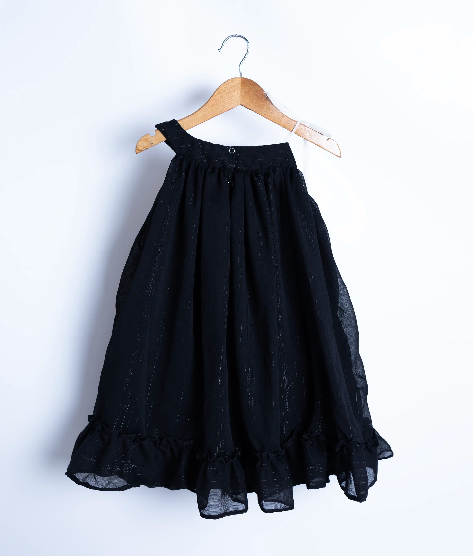 Back view of the black shimmer frock showing the adjustable tie and round neck button closure