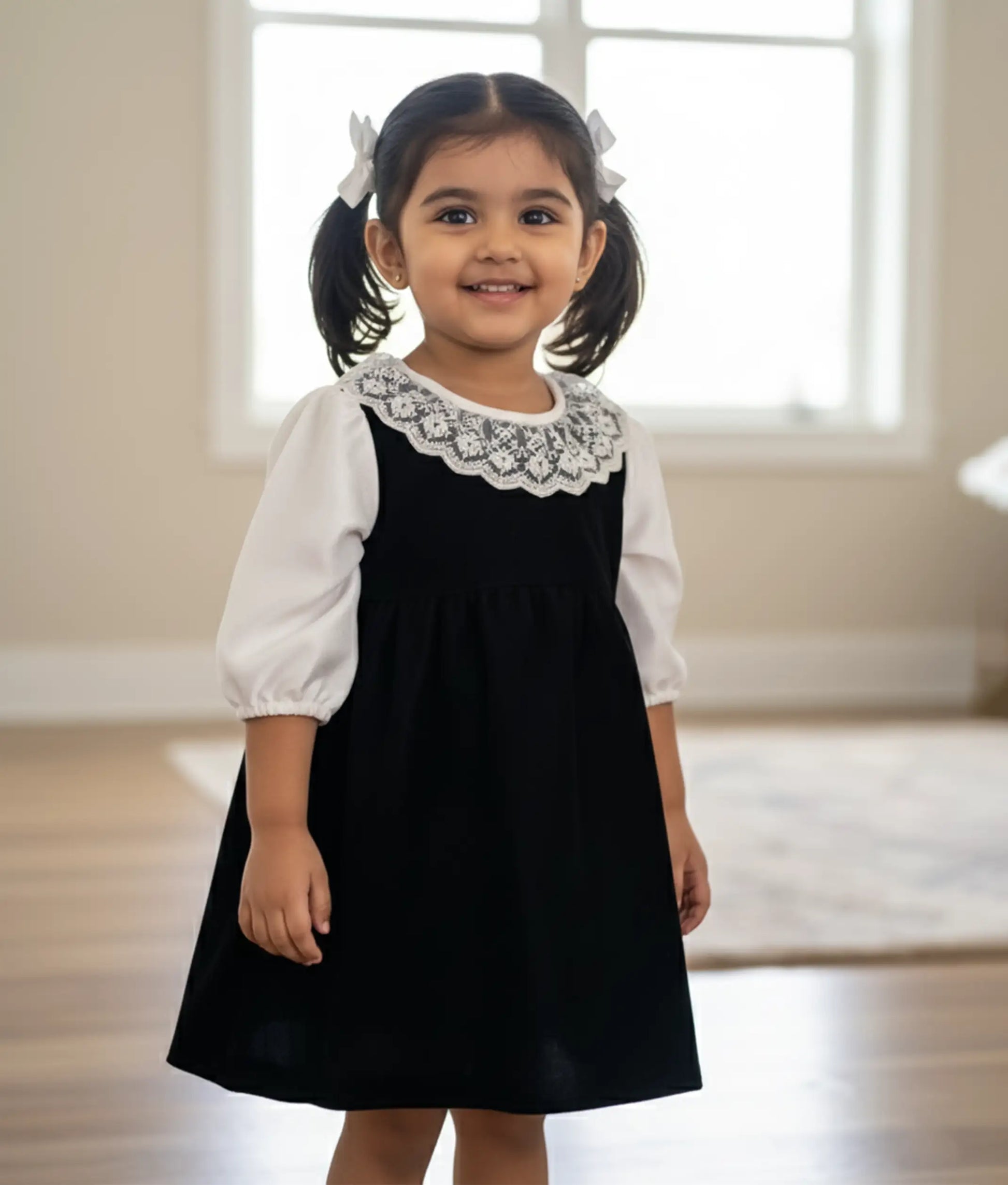 Black velvet A-line frock with elegant leg-o-mutton sleeves and white lace trim for baby girls.