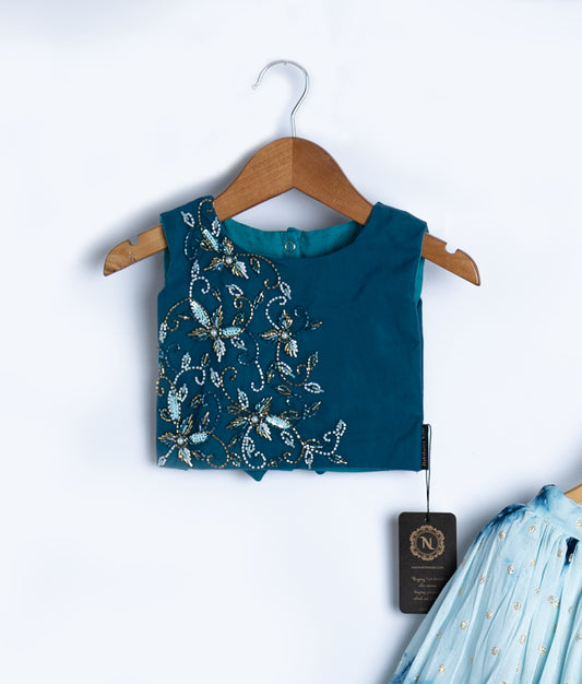 Close-up of blue baby dress top with intricate floral embroidery