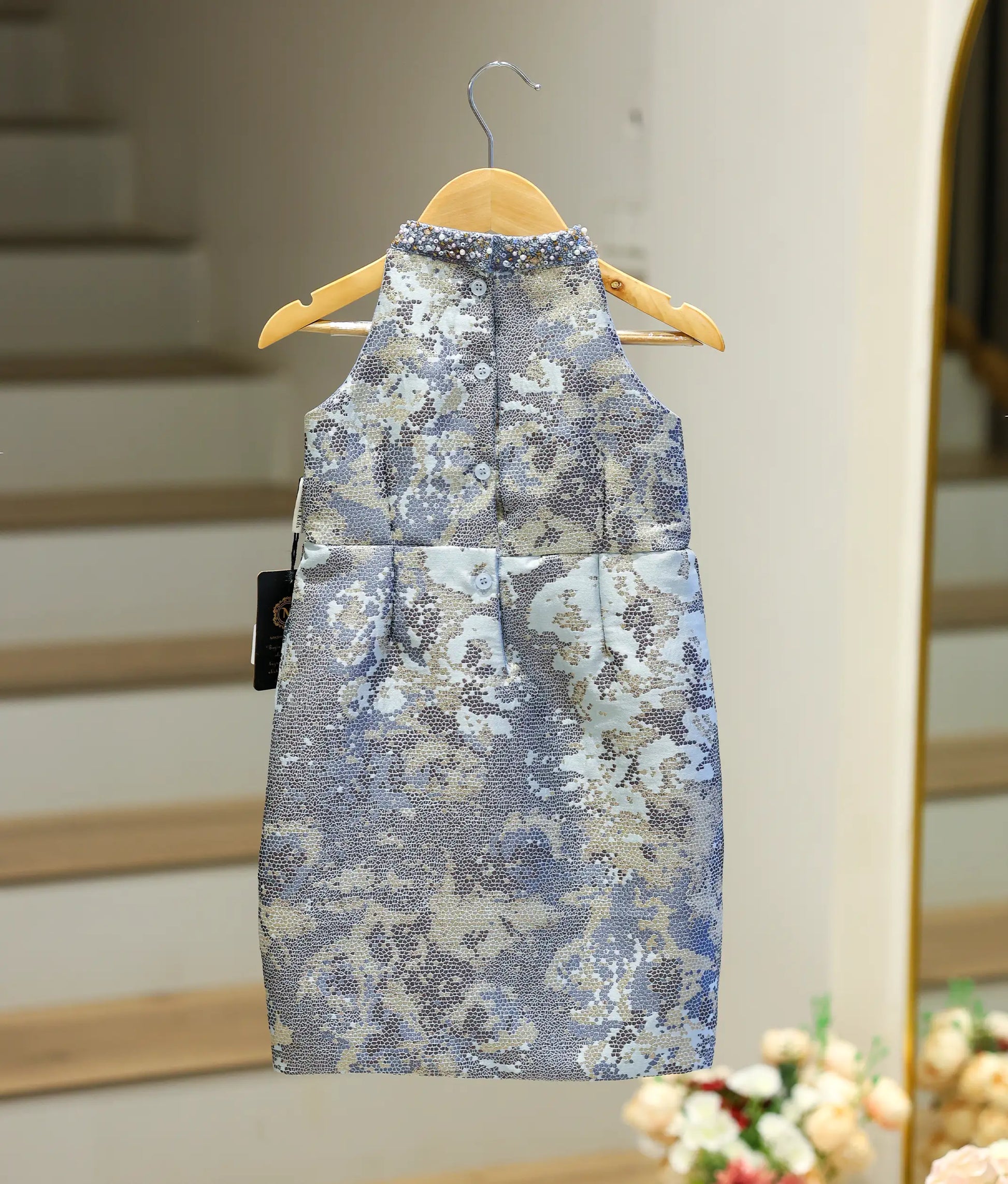 Back view of the blue fish-cut frock highlighting the halter back and shirt button closure.