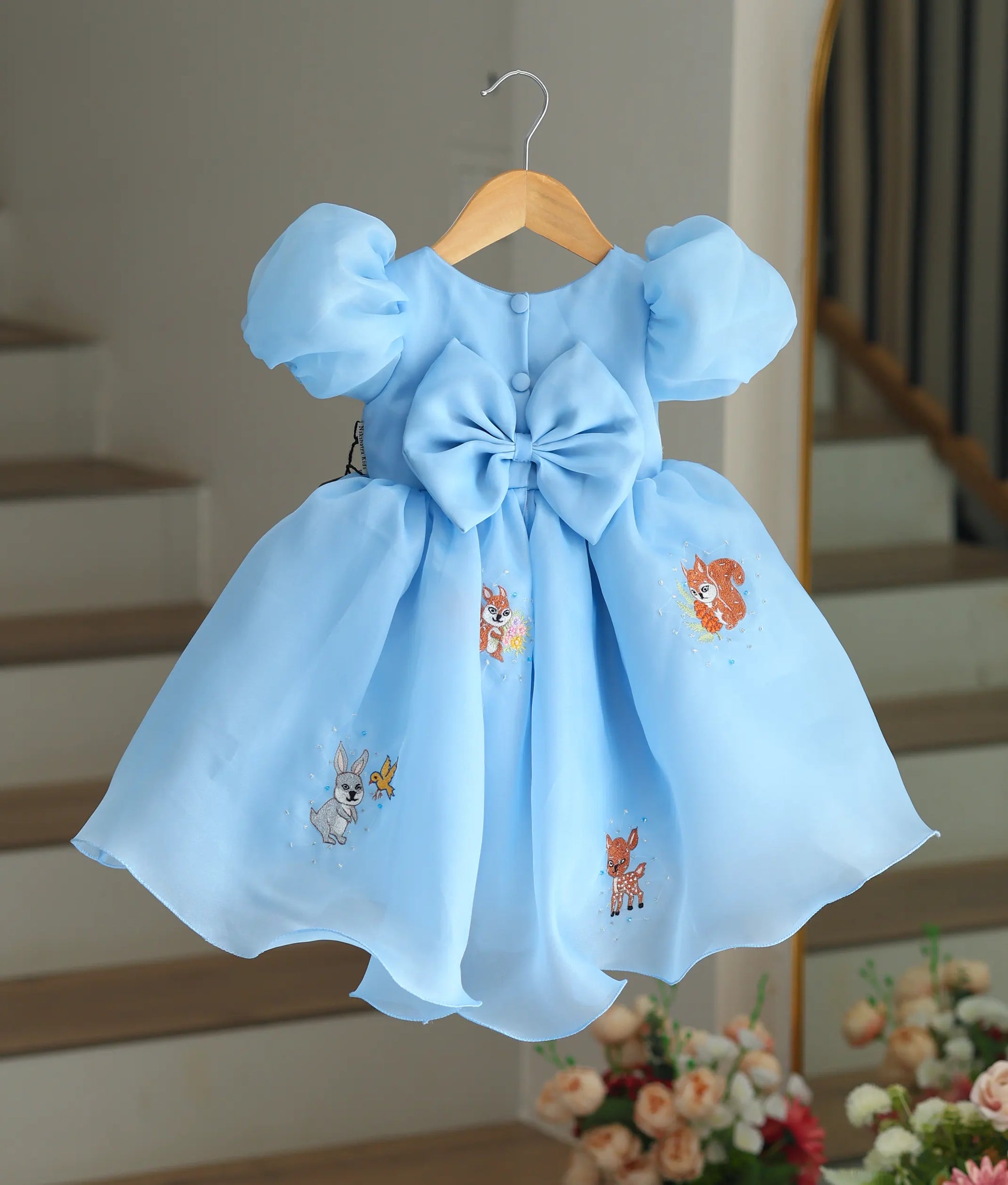 Back view of the sky blue frock showing the large bow and buttons.