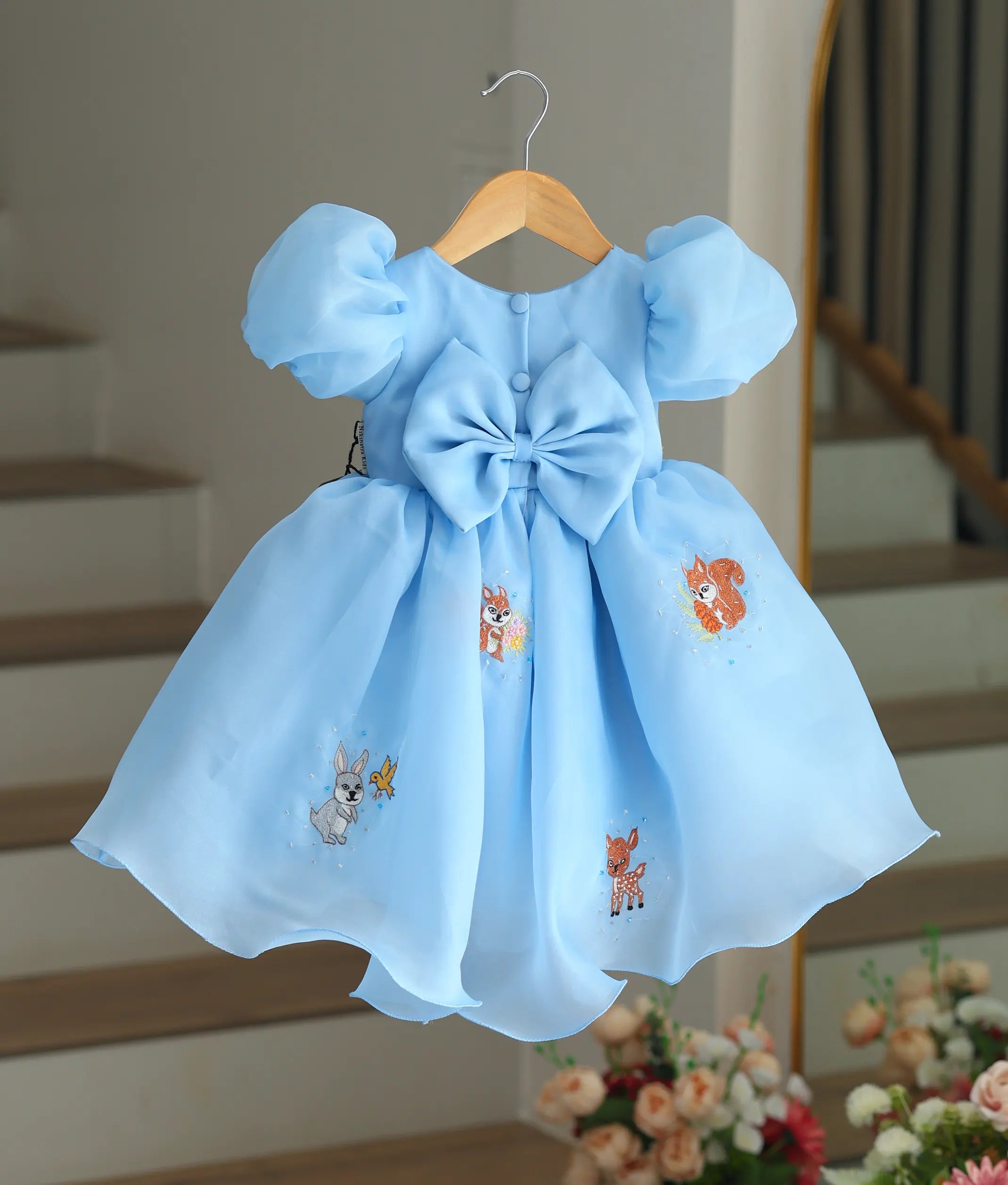 Back view of the sky blue frock showing the large bow and buttons.