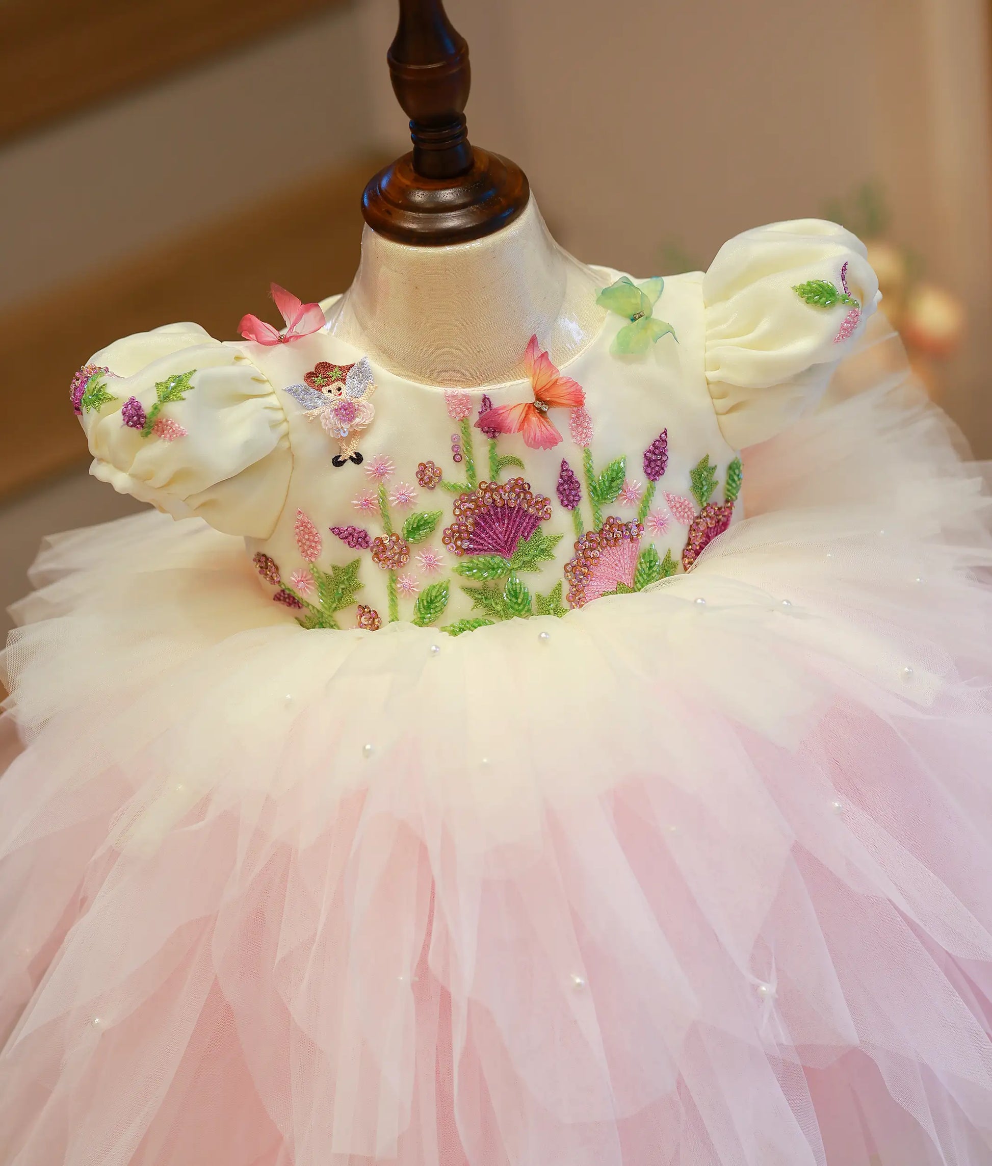 Close-up of the floral handwork, butterfly motifs, and handworked puff sleeves on the off-white top