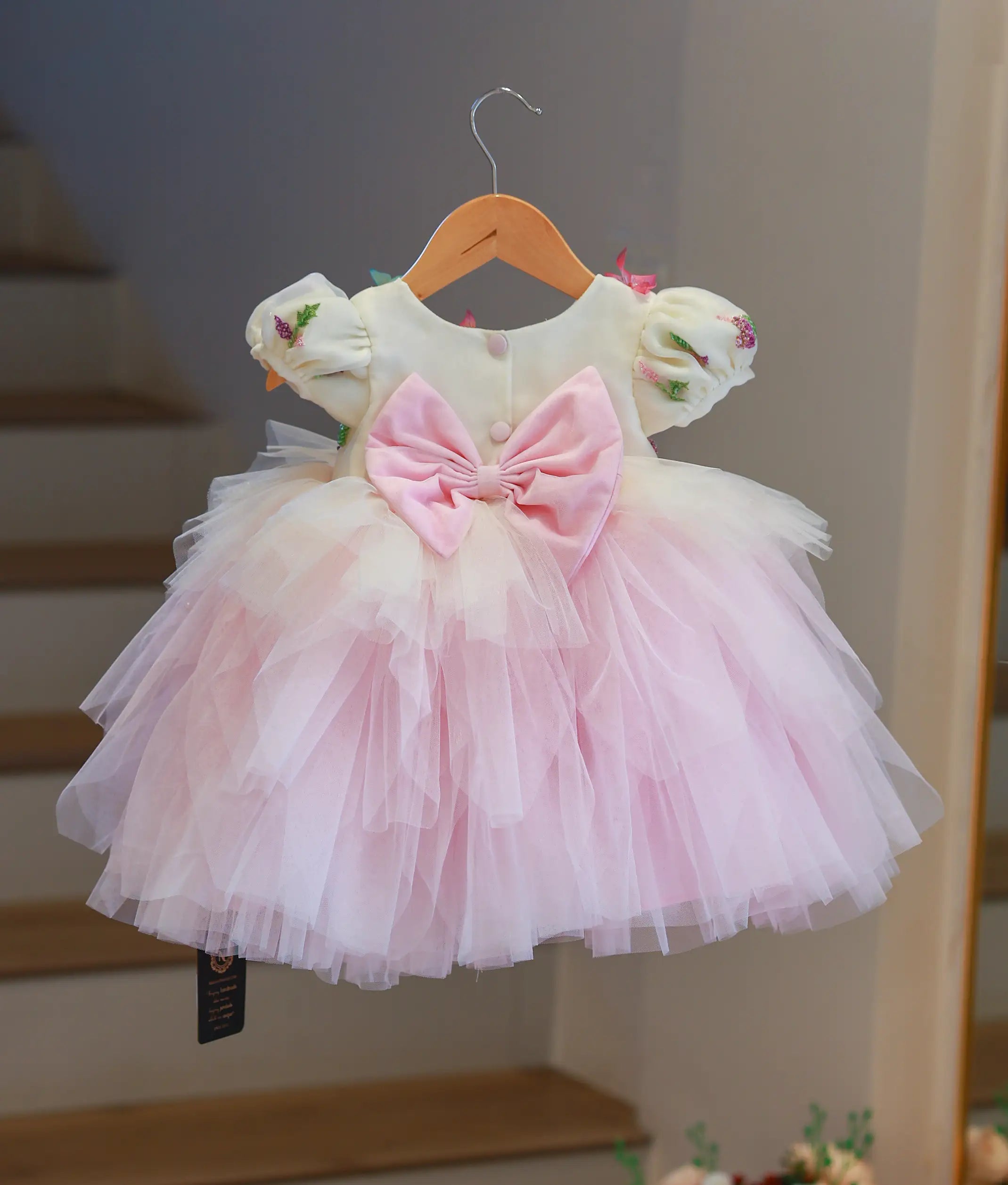 Back view of the dress highlighting the decorative bow and the step-pattern tulle bottom