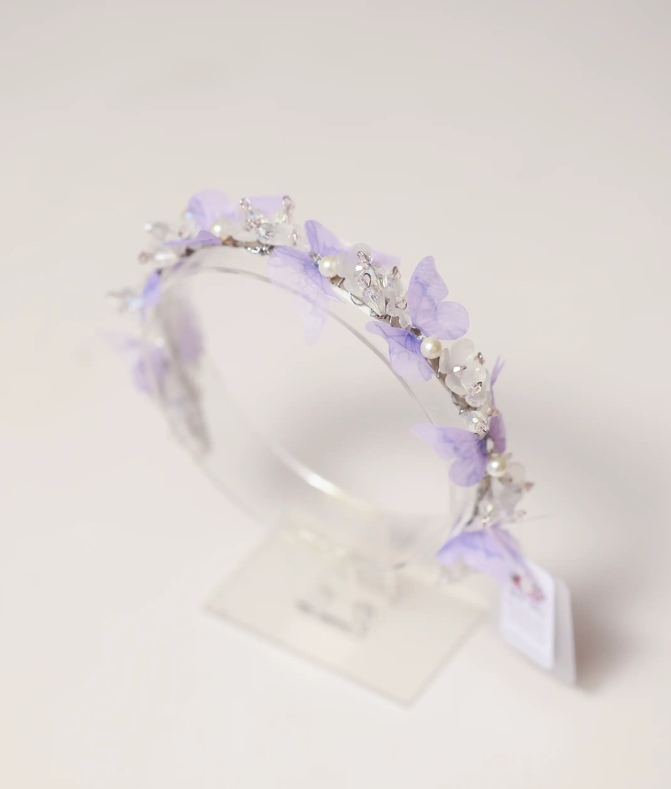 Close-up of the handcrafted tiara showing lavender butterflies, white pearls, and shimmering crystal beads