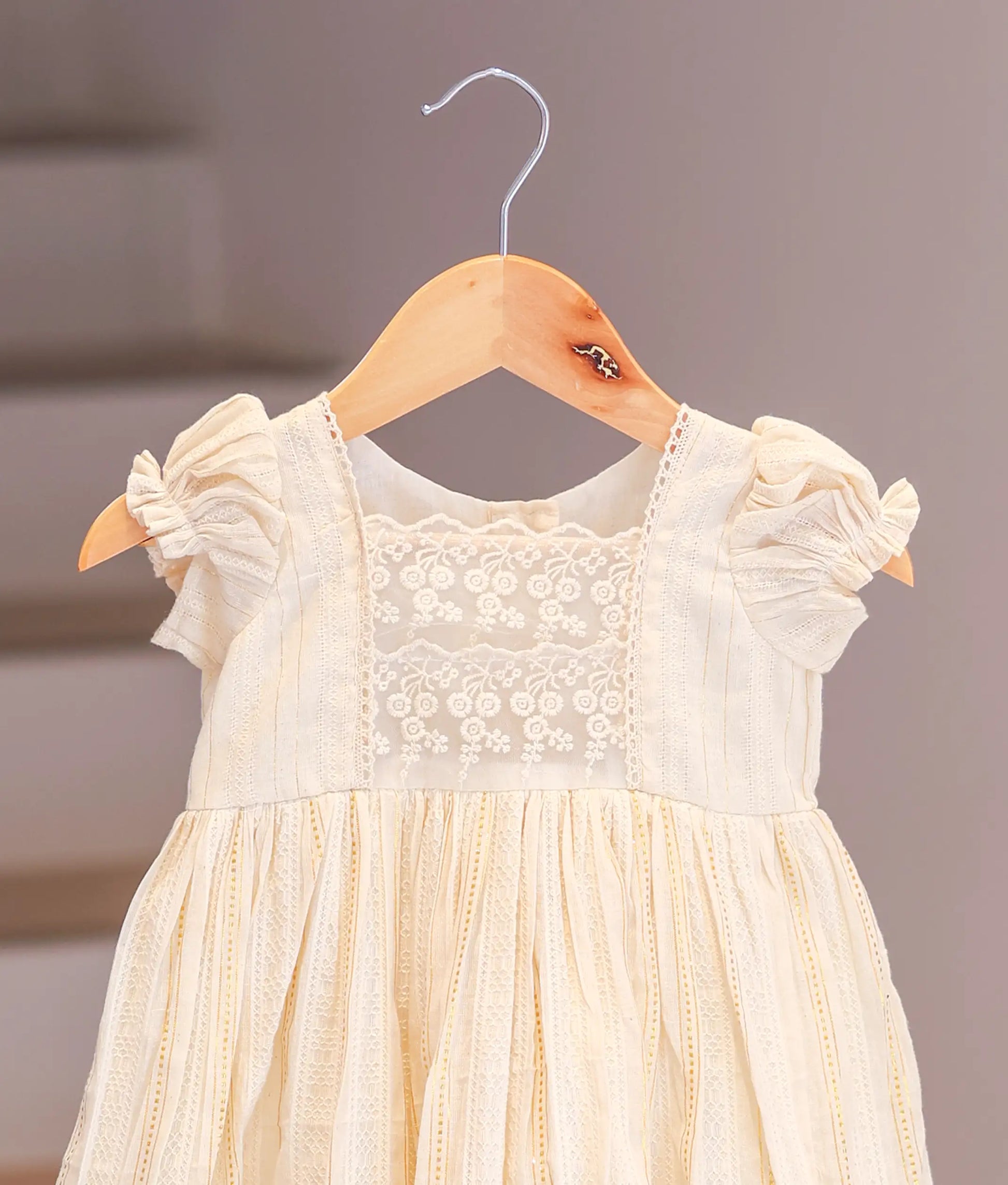 Close-up of the soft cotton fabric and vibrant floral print on the casual baby frock