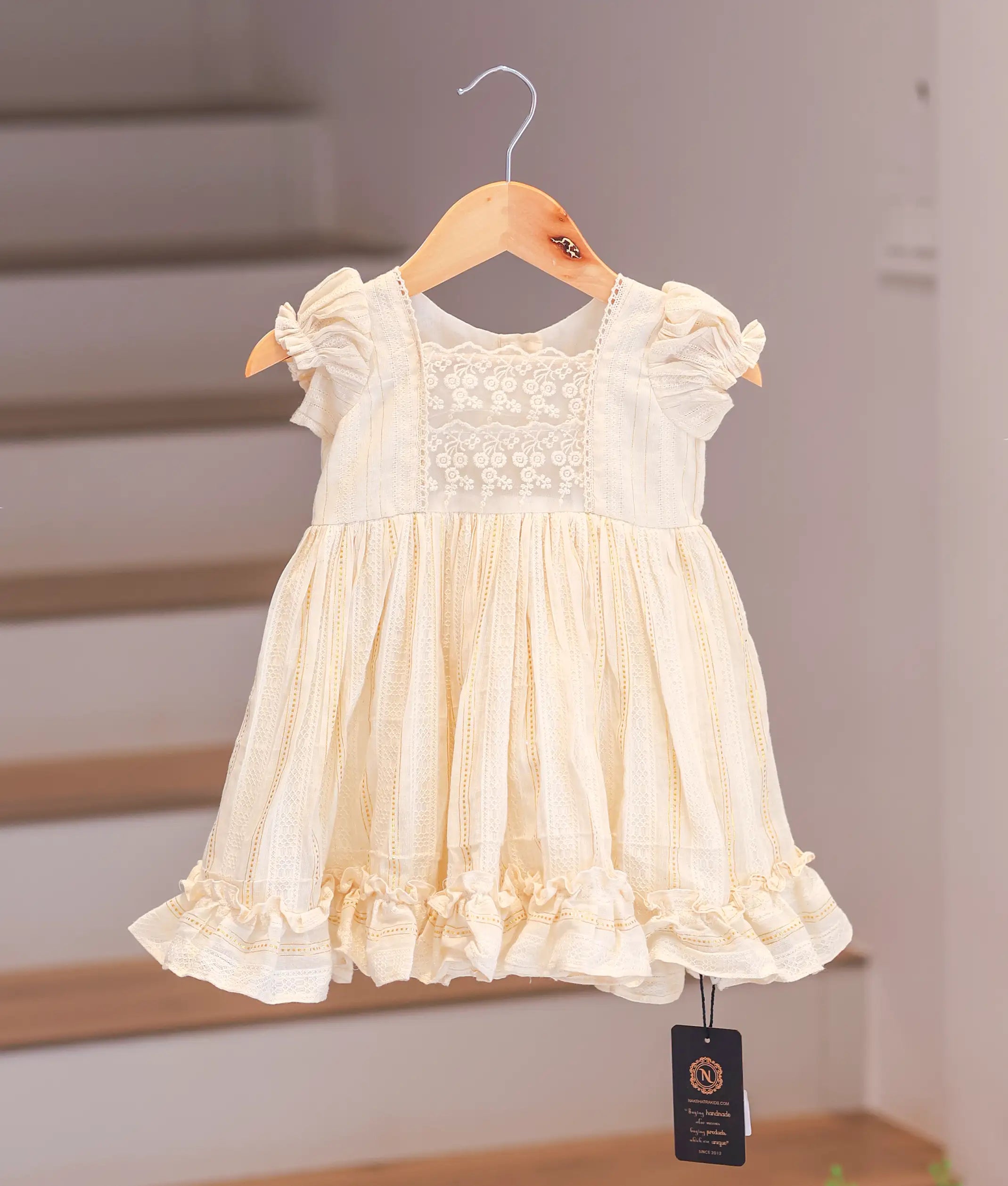 Front view of a casual floral print cotton frock for baby girls featuring a flared skirt and cap sleeves