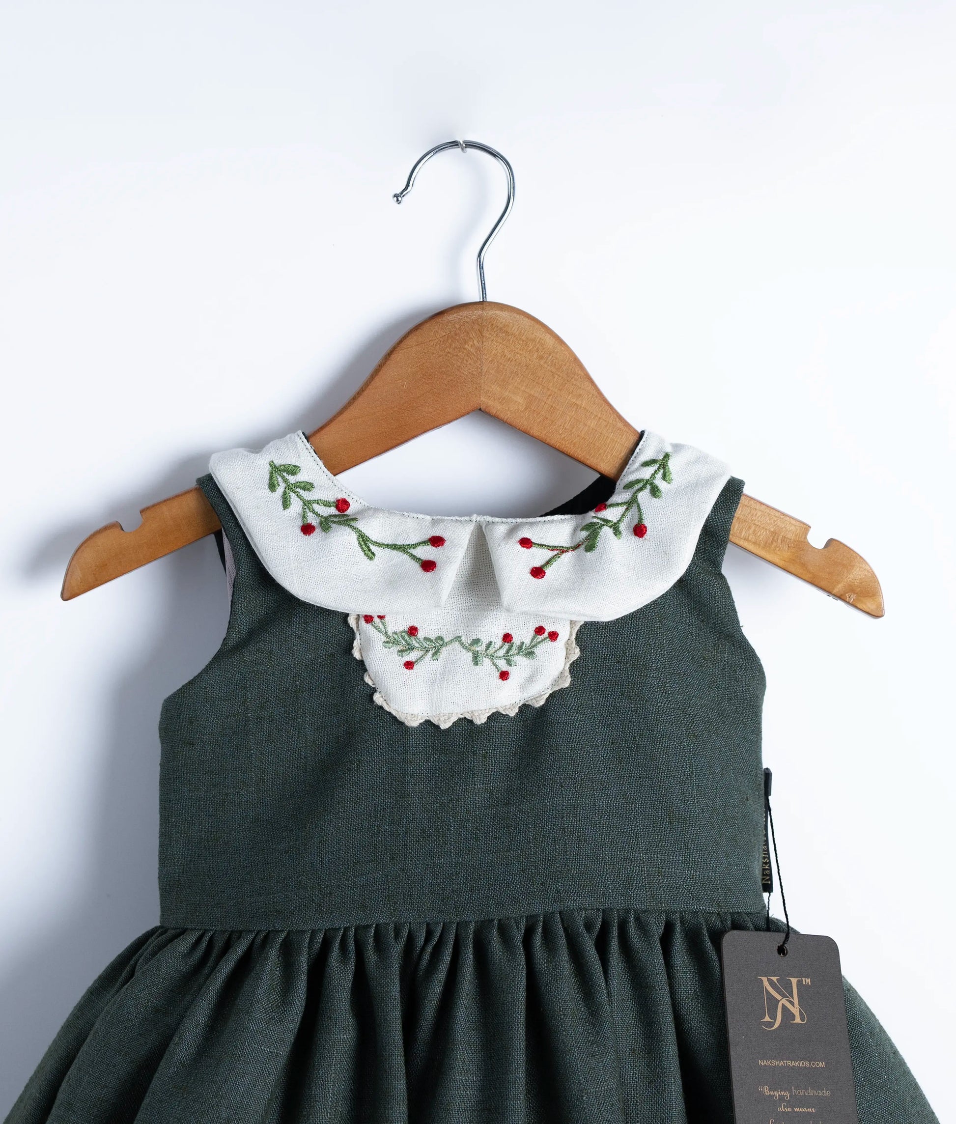 Close view of the Peter Pan collar, showing the hand-embroidered red berries and green foliage.