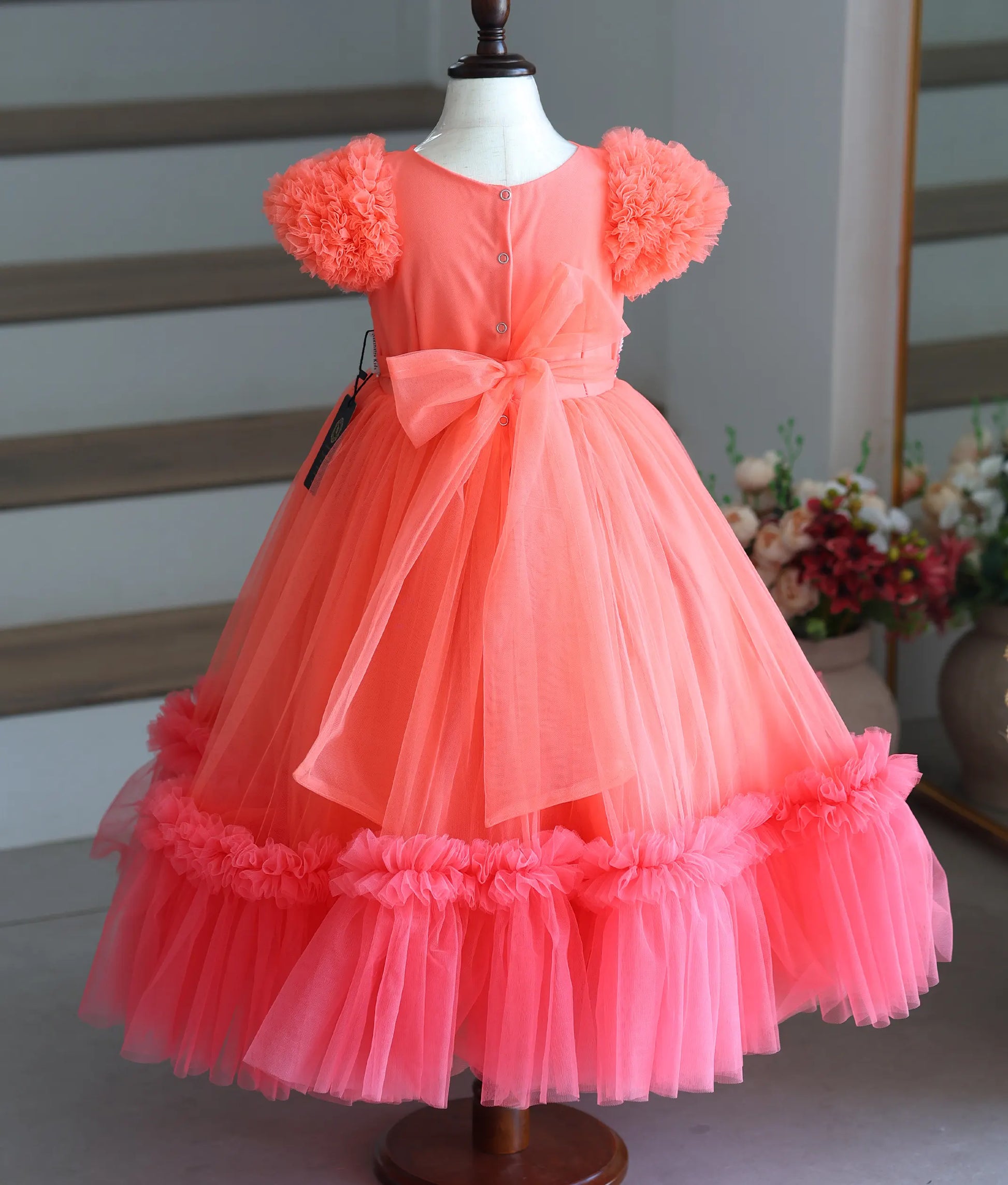 Back view of the gown showing the button closure and large net bow.