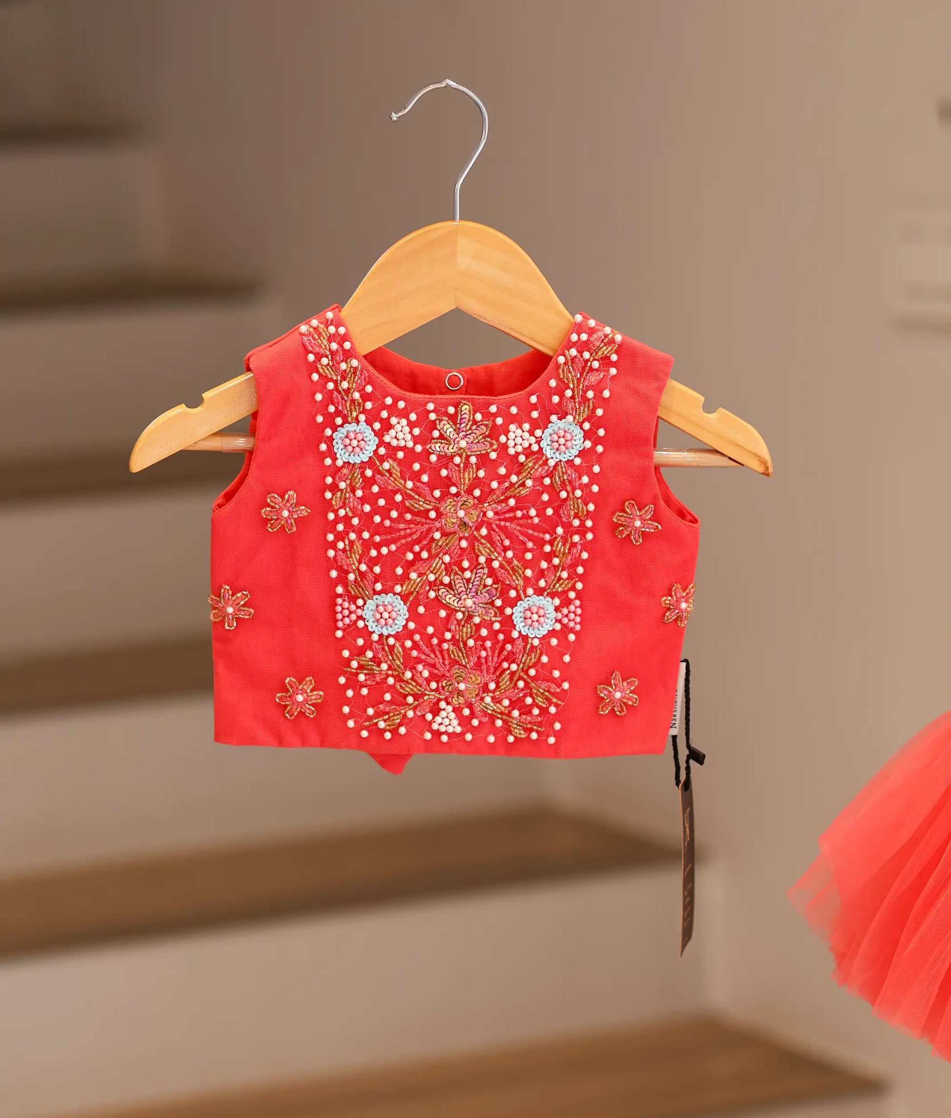 Close-up of the intricate floral handwork, sparkly beads, and matching waistband on the dark pink top