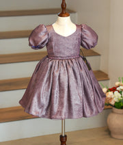 Front view of a shimmering dark purple milan foil birthday frock for baby girls featuring short puff sleeves and a pleated flared skirt