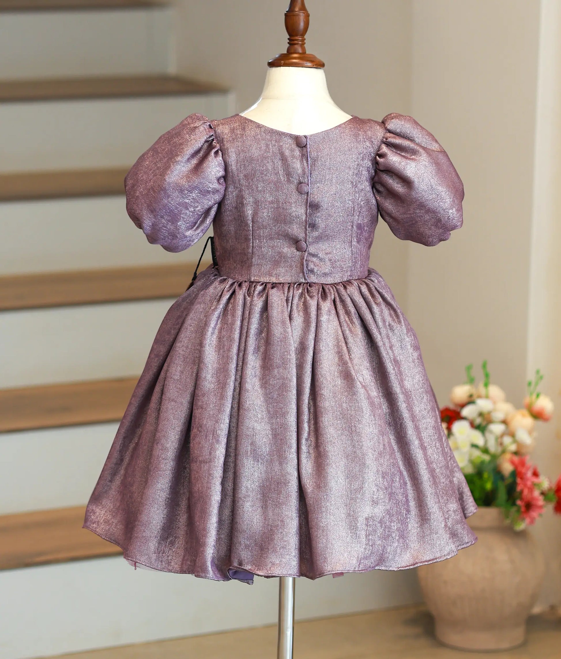 Back view of dark purple milan foil party dress showing the round neckline and the elegant show button closure