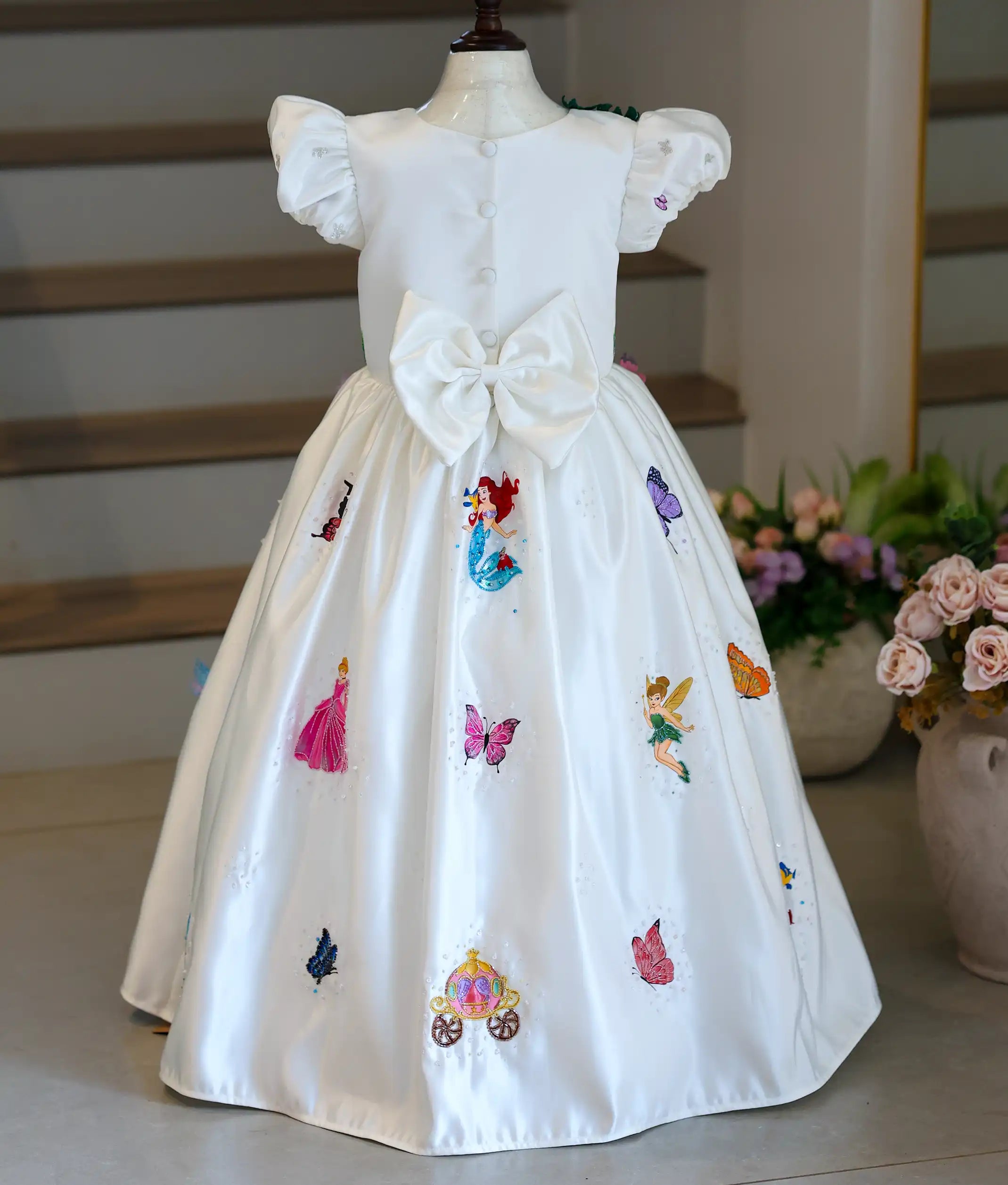 Back view of the ivory gown showing the button closure and large structured bow.