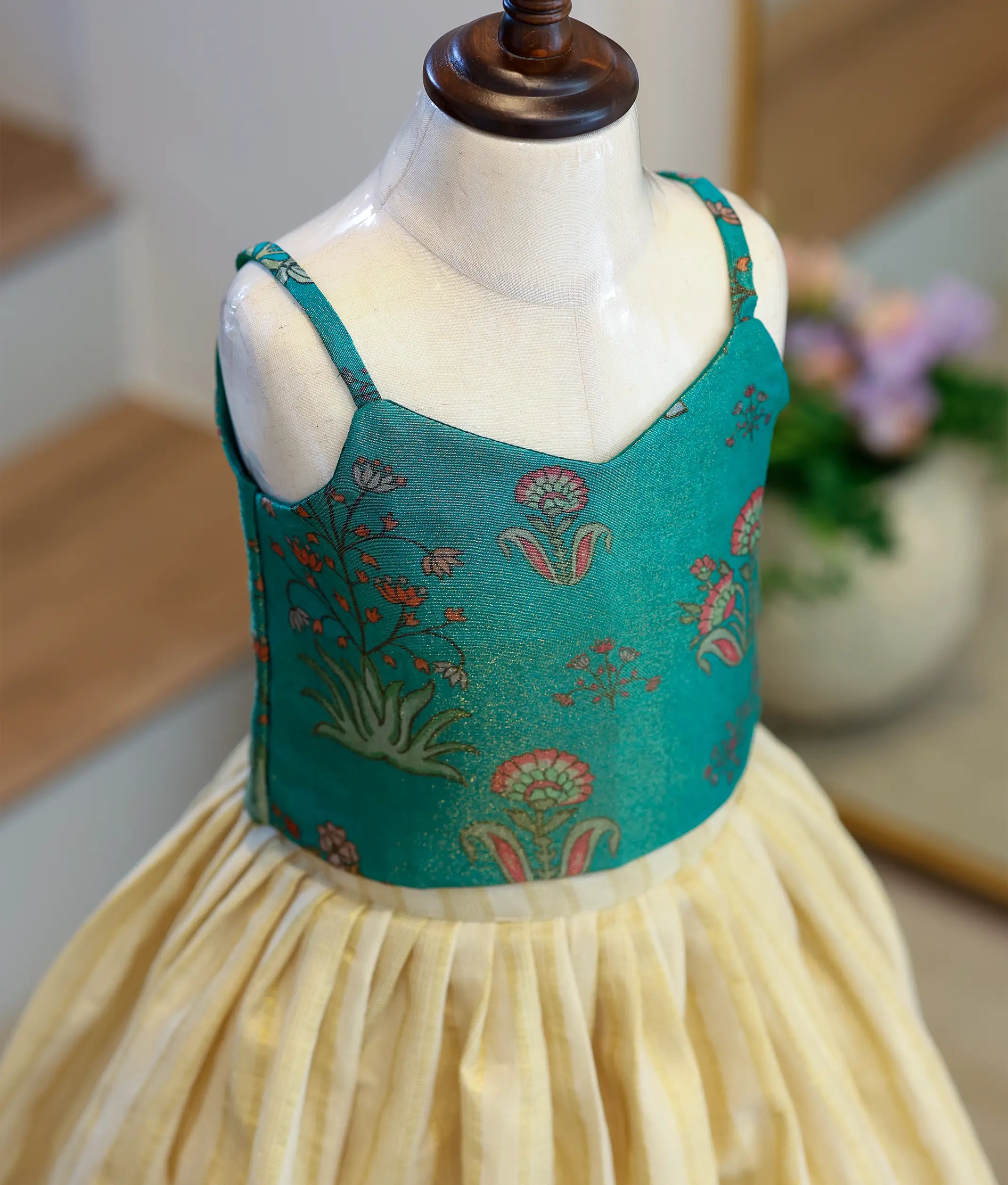 Close-up of the emerald green top showing the shoulder straps.