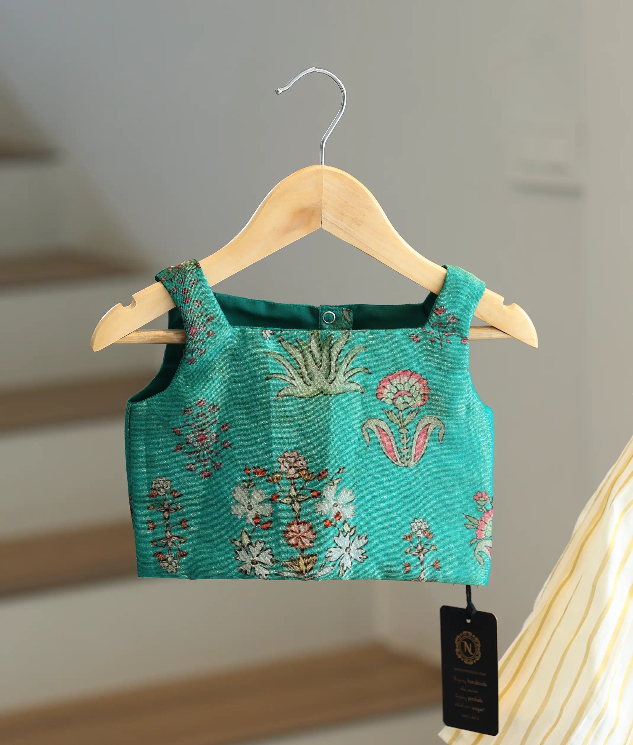Close-up of the emerald green top showing the shoulder straps.