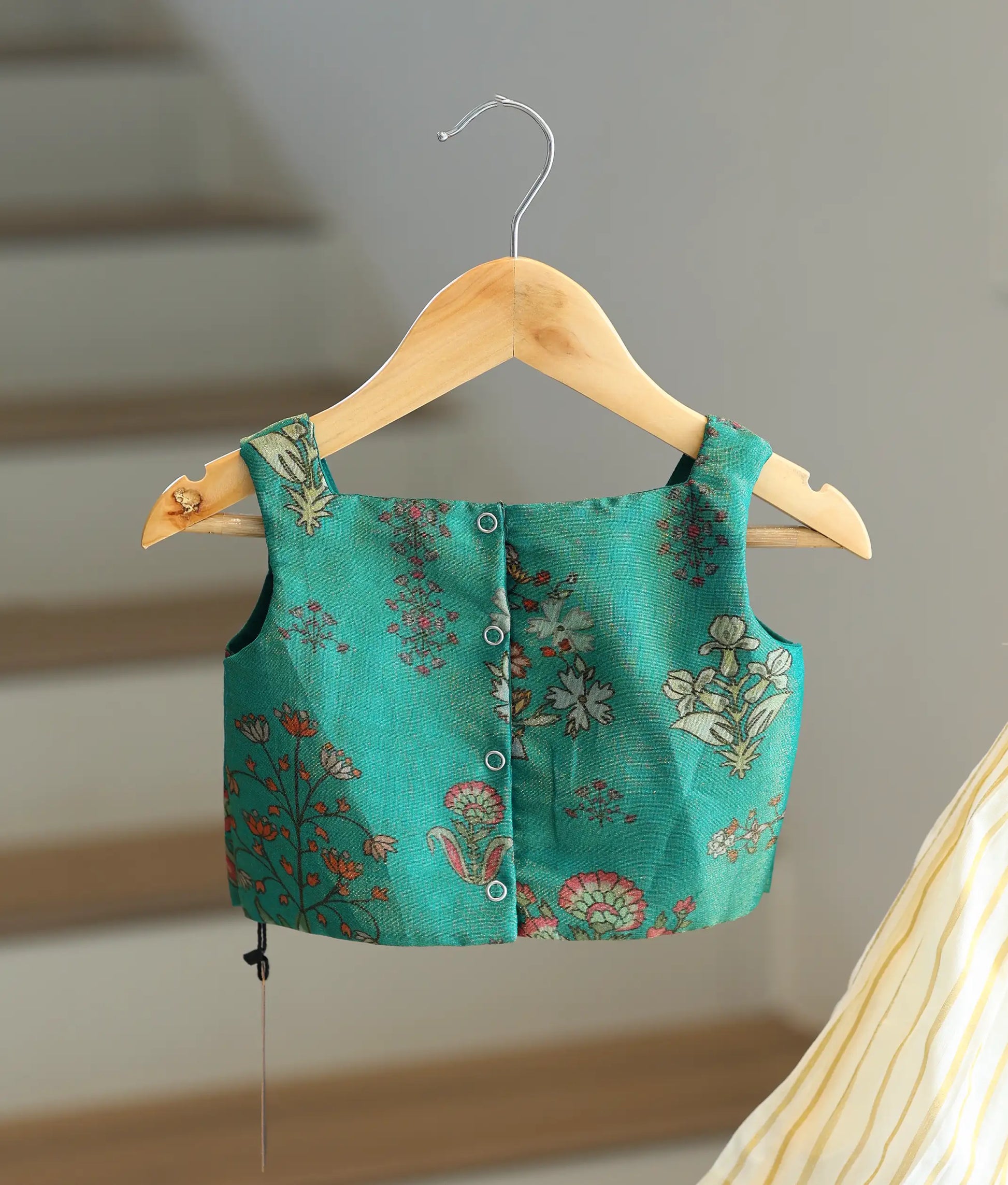 Back view of the emerald green top showing the row of secure button closures.