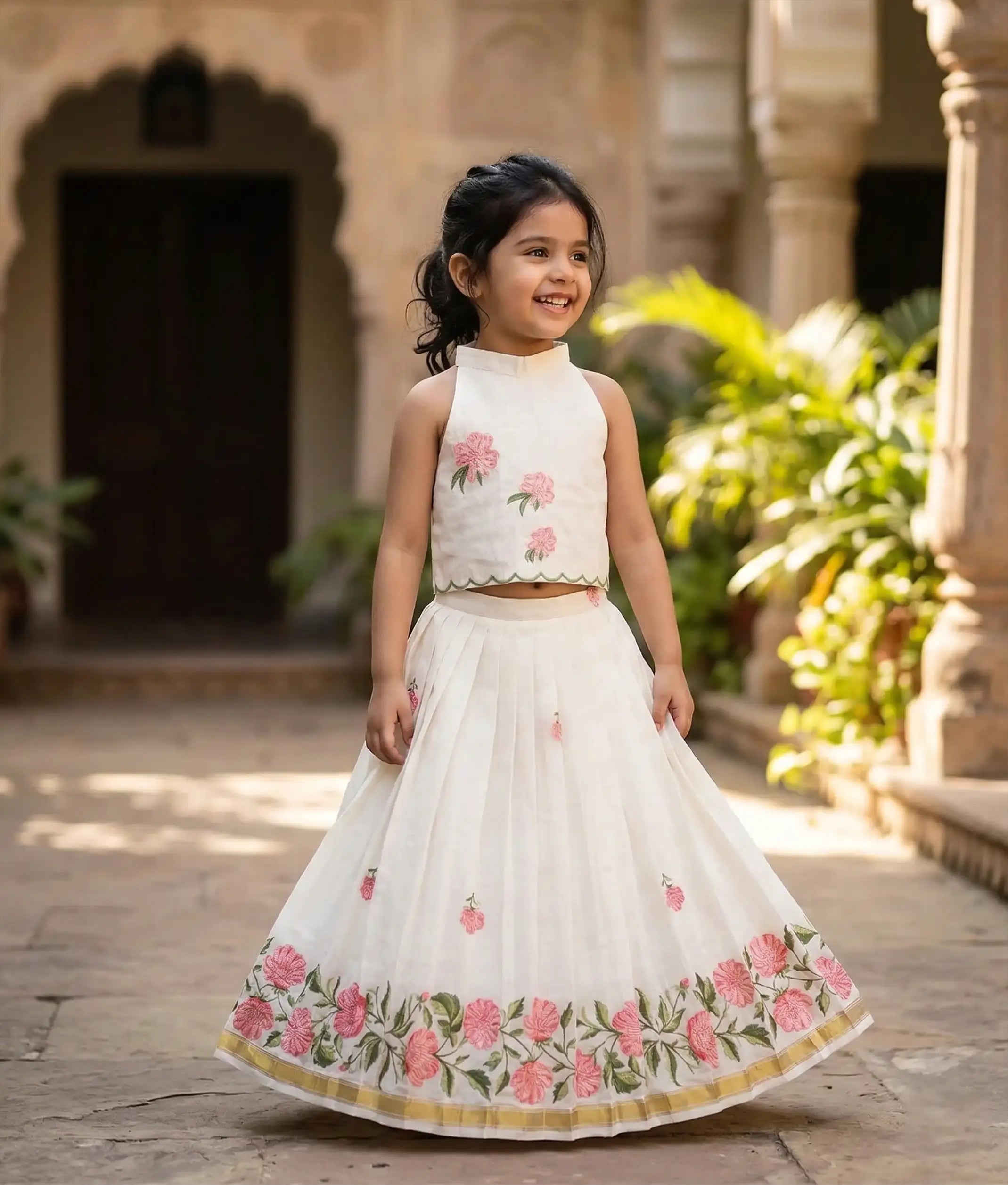 Baby girl wearing an ethnic off-white skirt and top with floral embroidery.