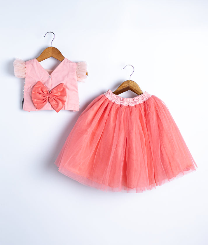 Flat lay of peach pink baby dress set with lace top and tulle skirt