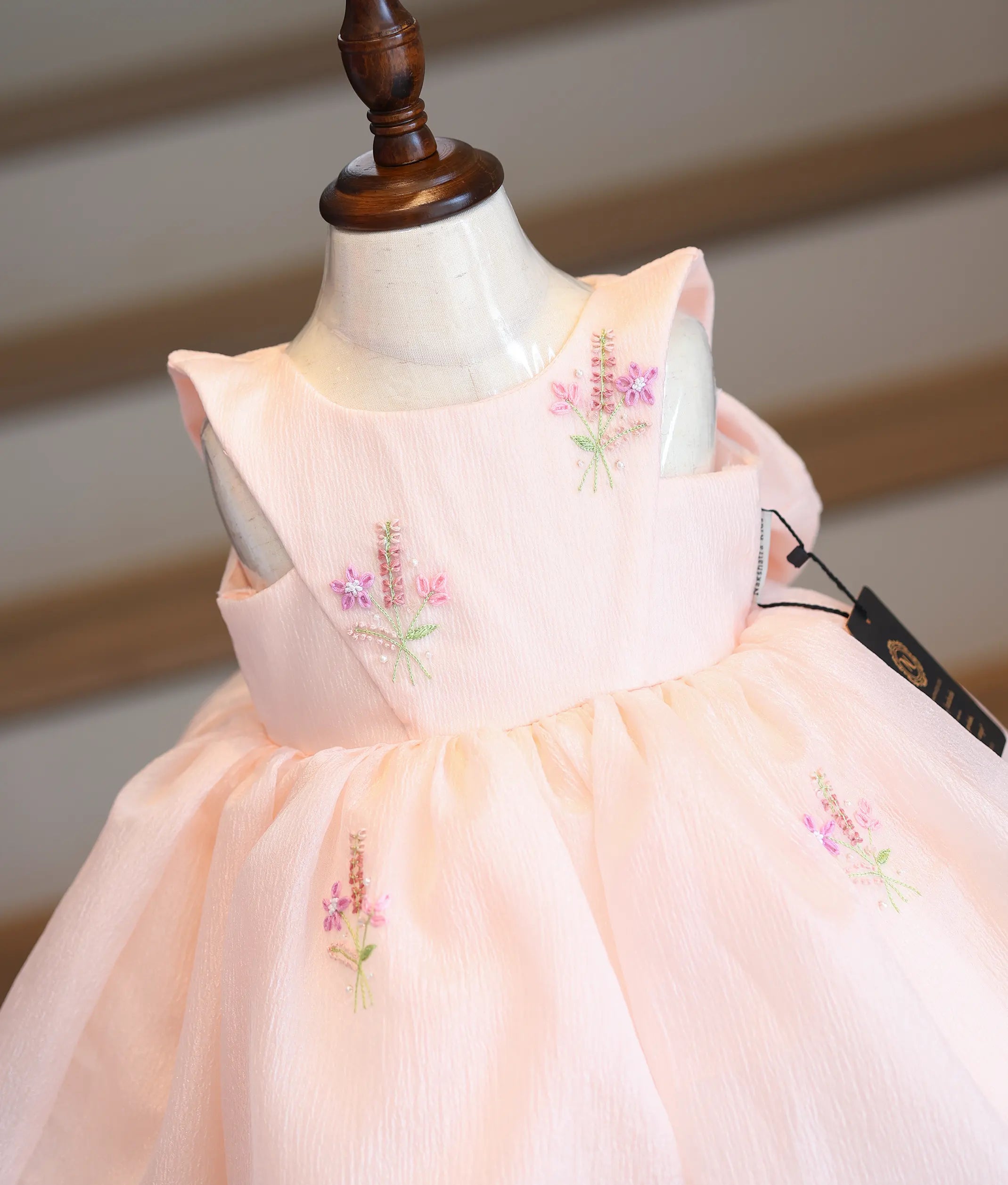 Close-up of the floral handwork using beads and threads on the peach organza bodice.