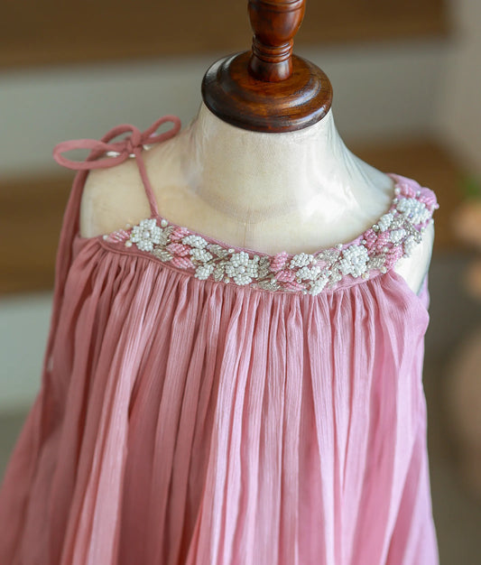 Close-up of the pink and white floral beadwork on the neckline of the onion pink shimmer frock.