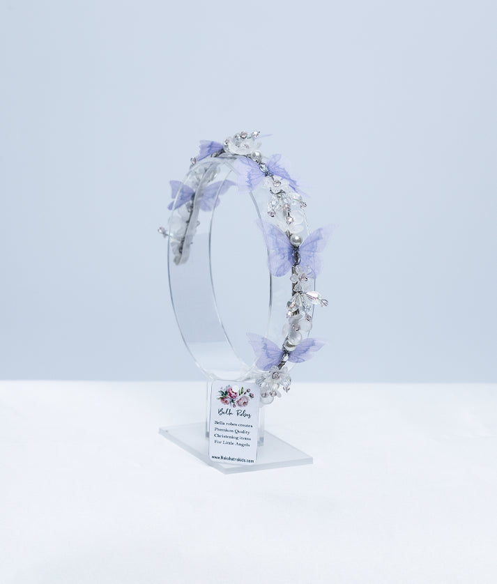 Front view of a white lace hairband for babies with purple and orange floral embroidery and green leaves