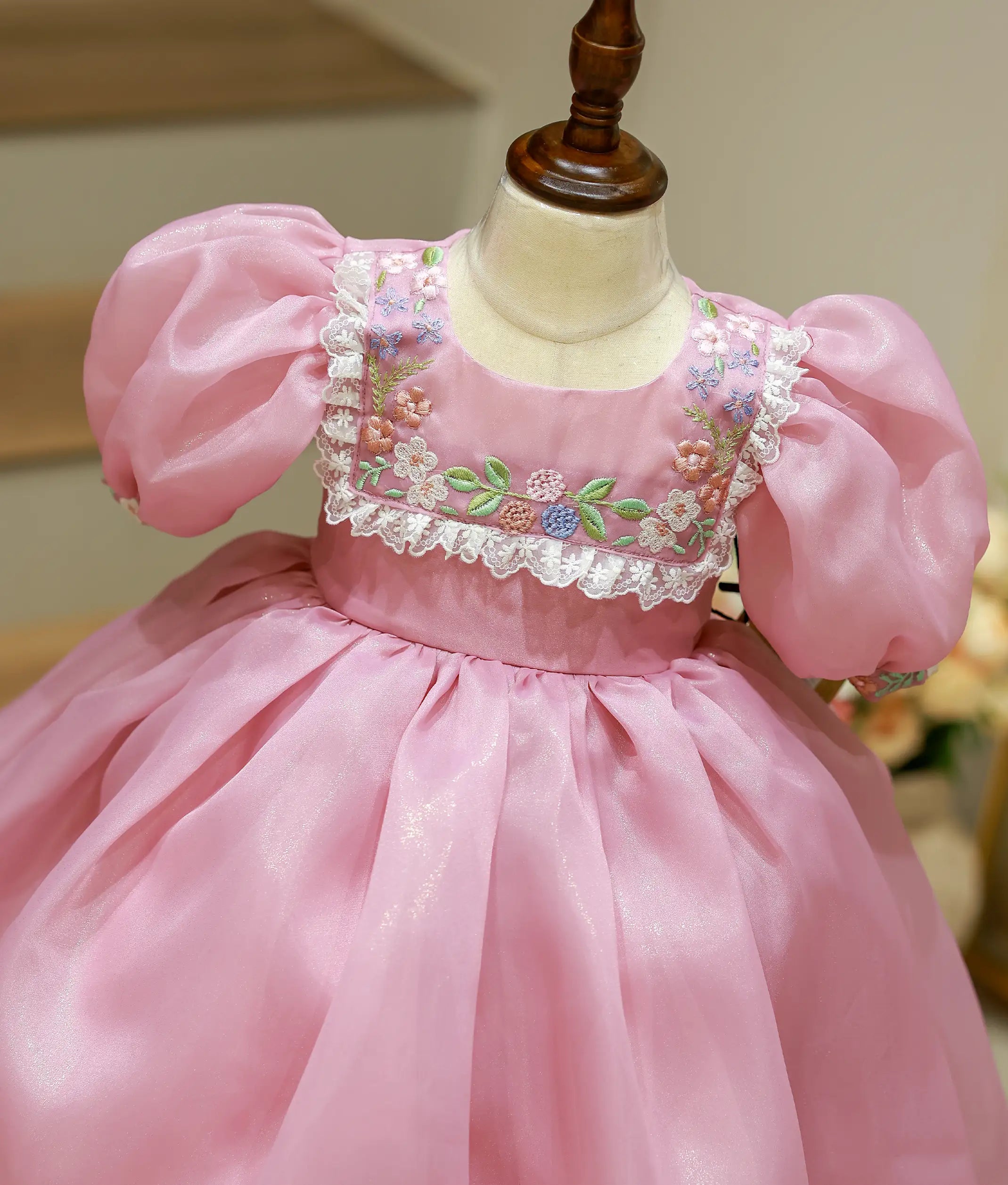 Close-up of the delicate floral embroidery, lace trimmings, and shimmer organza fabric on the lavender birthday frock