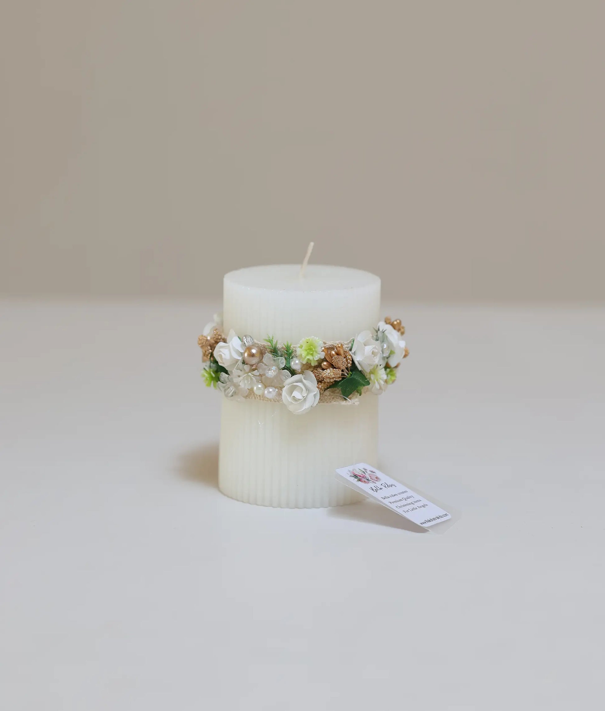 Decorative pillar baptism candle with silk floral arrangement, white lace, and gold pearl accents