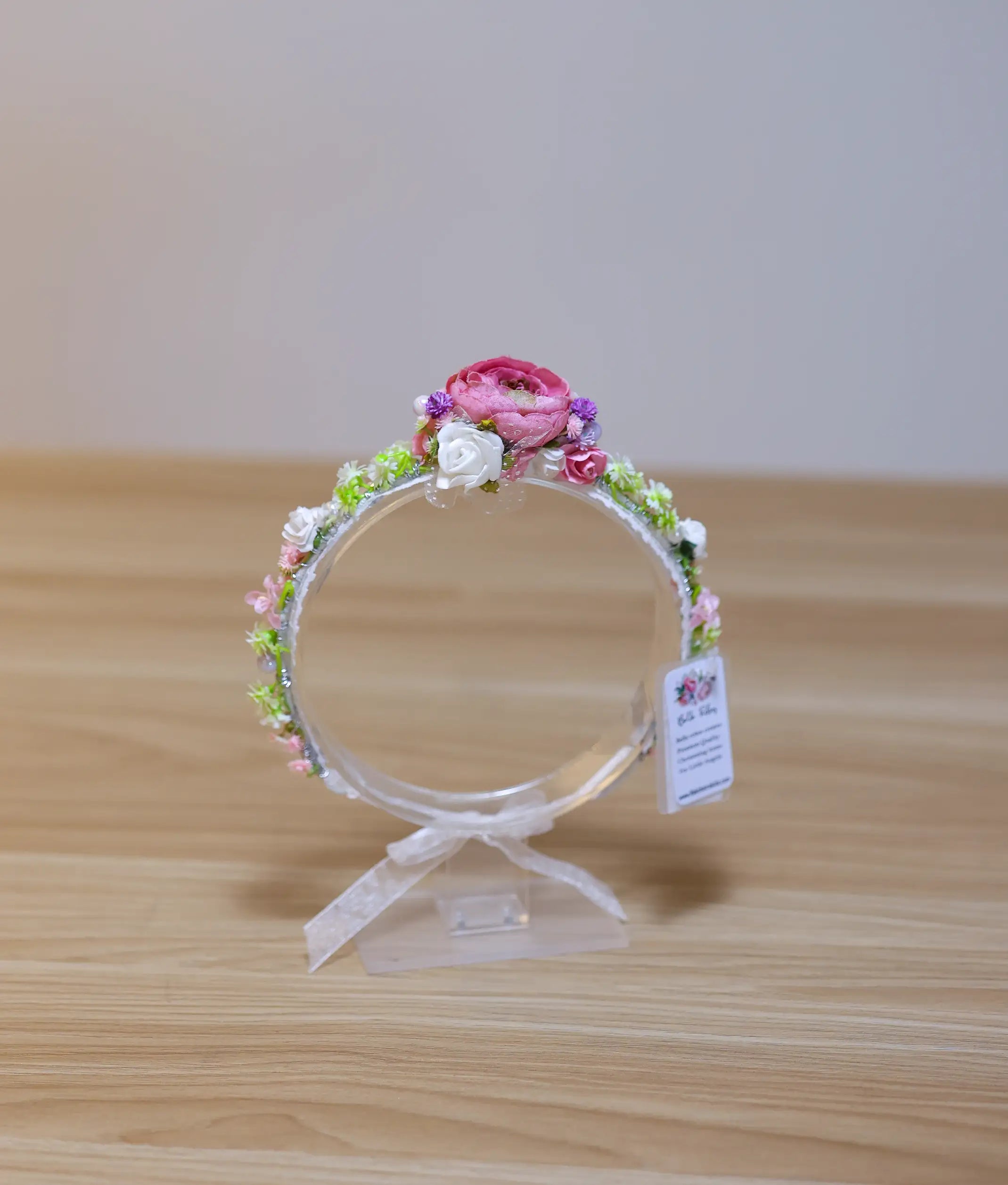 Close-up of the handcrafted tiara showing detailed pink roses, white blossoms, and green leaf accents