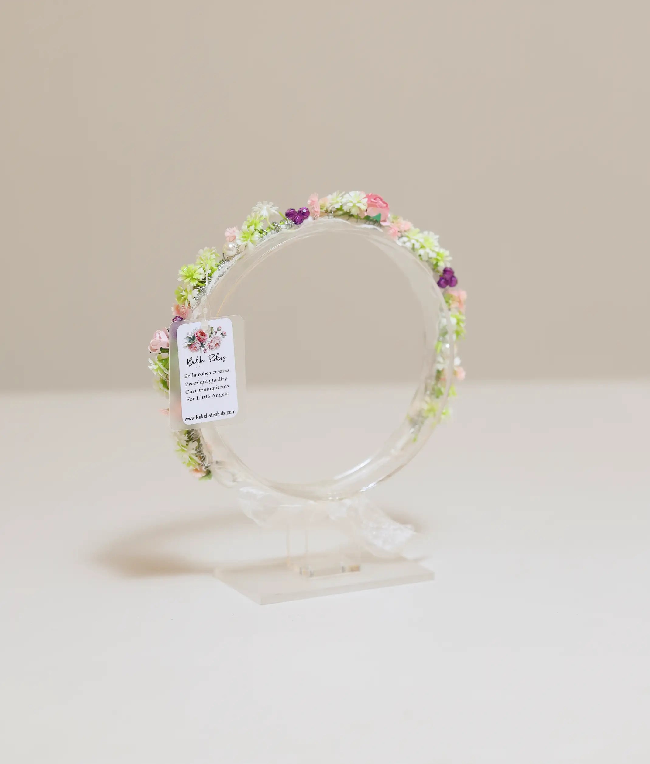 Close-up of the handcrafted tiara showing detailed white roses, pink blossoms, and green buds