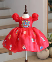 Front view of a bright red organza Paw Patrol theme party frock for girls on a mannequin display.