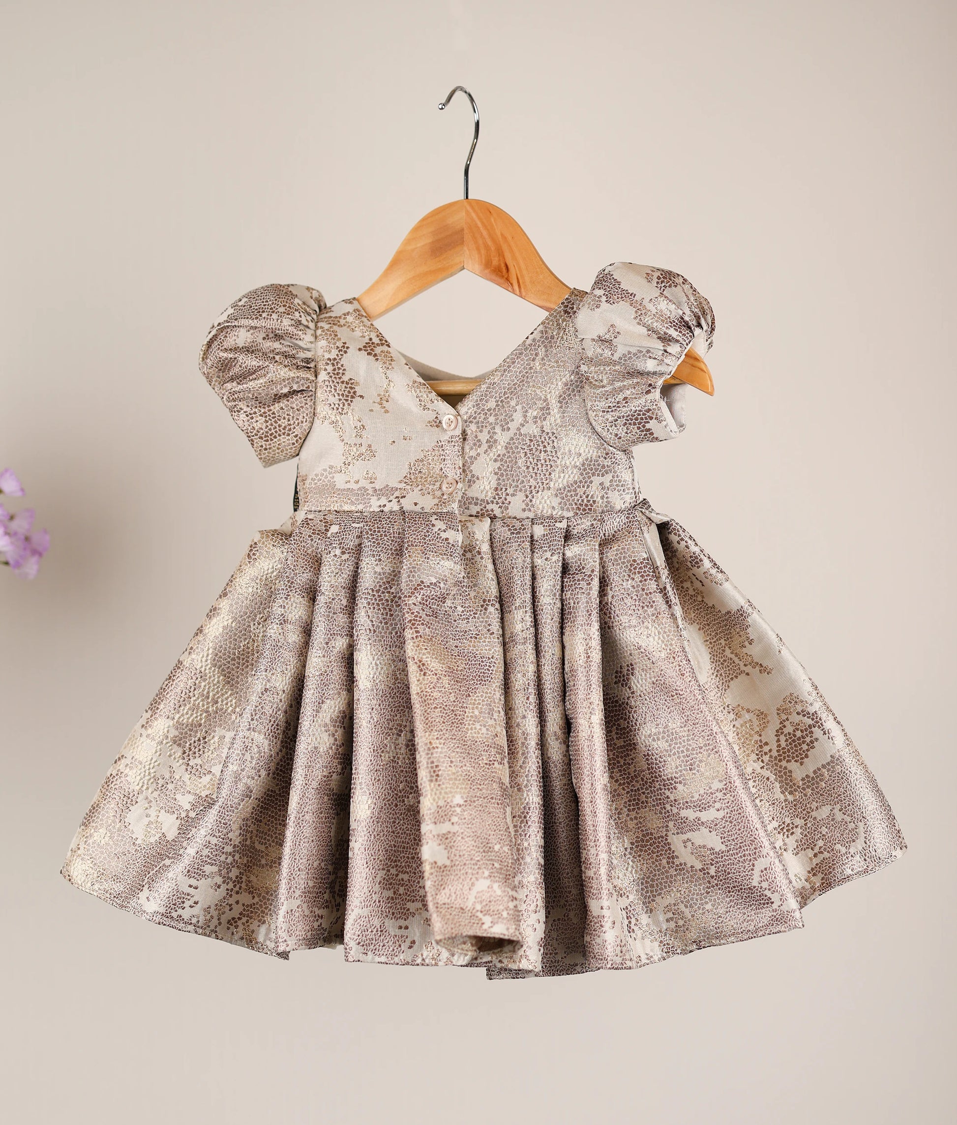 Back view of the gold birthday frock highlighting the V-neckline and shirt button closure.