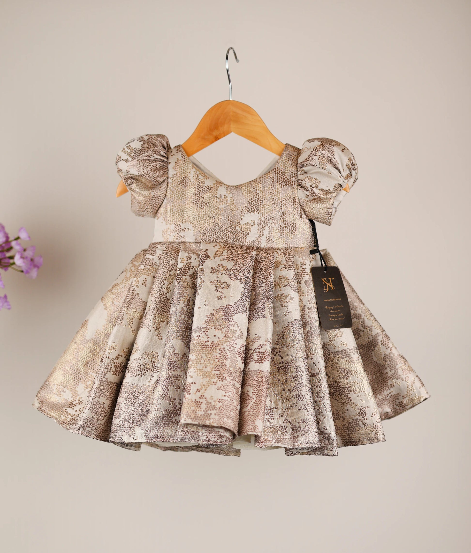 Front view of a gold jacquard organza frock for girls featuring a V-neck and puff sleeves.